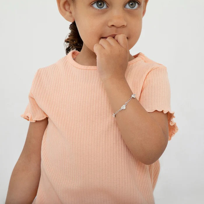 Young child wearing a silver chain bracelet with heart charms on wrist showcasing adorable bracelet designs for young children