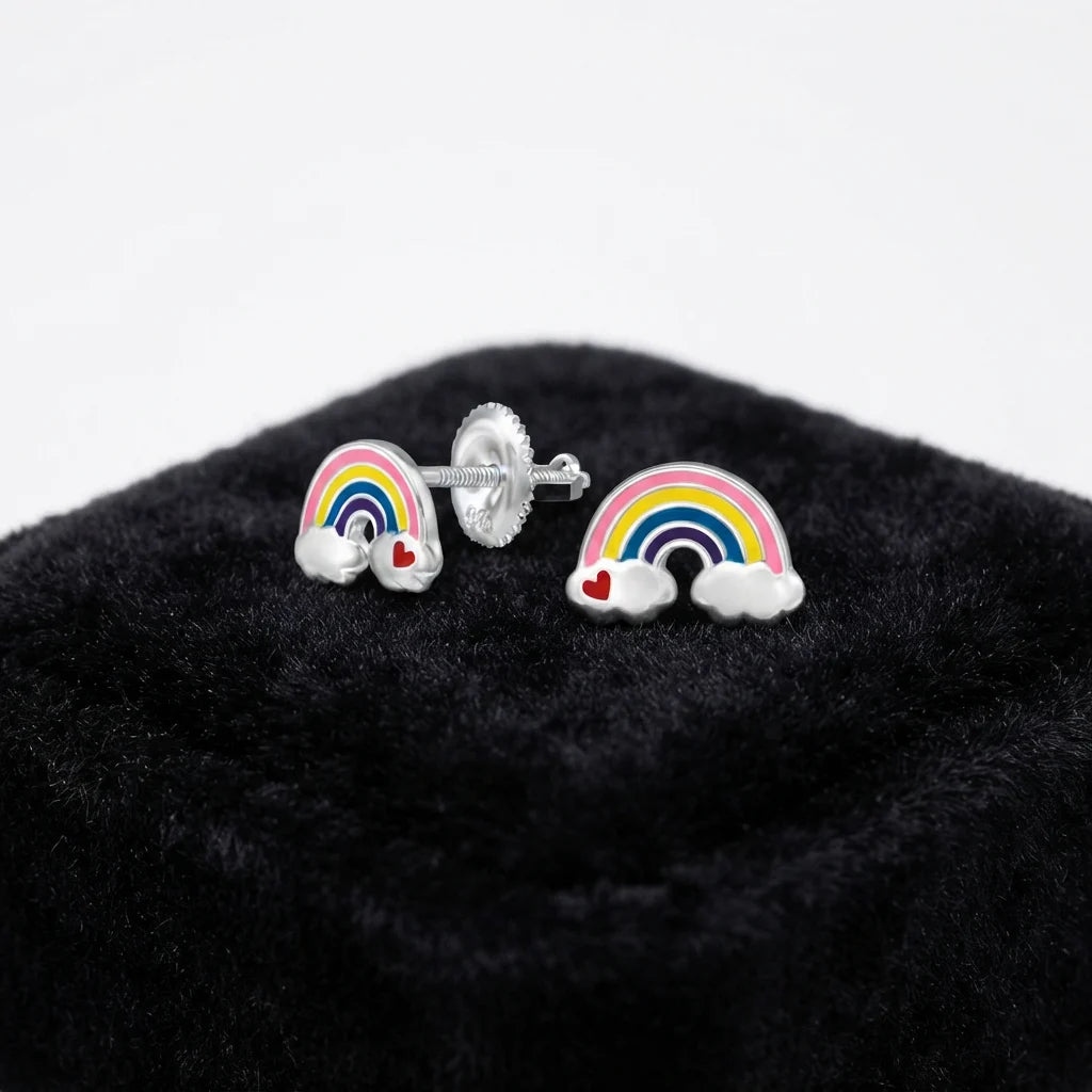 A pair of silver rainbow stud earrings with white clouds and small red hearts, displayed on a black velvet jewelry box against a white background.