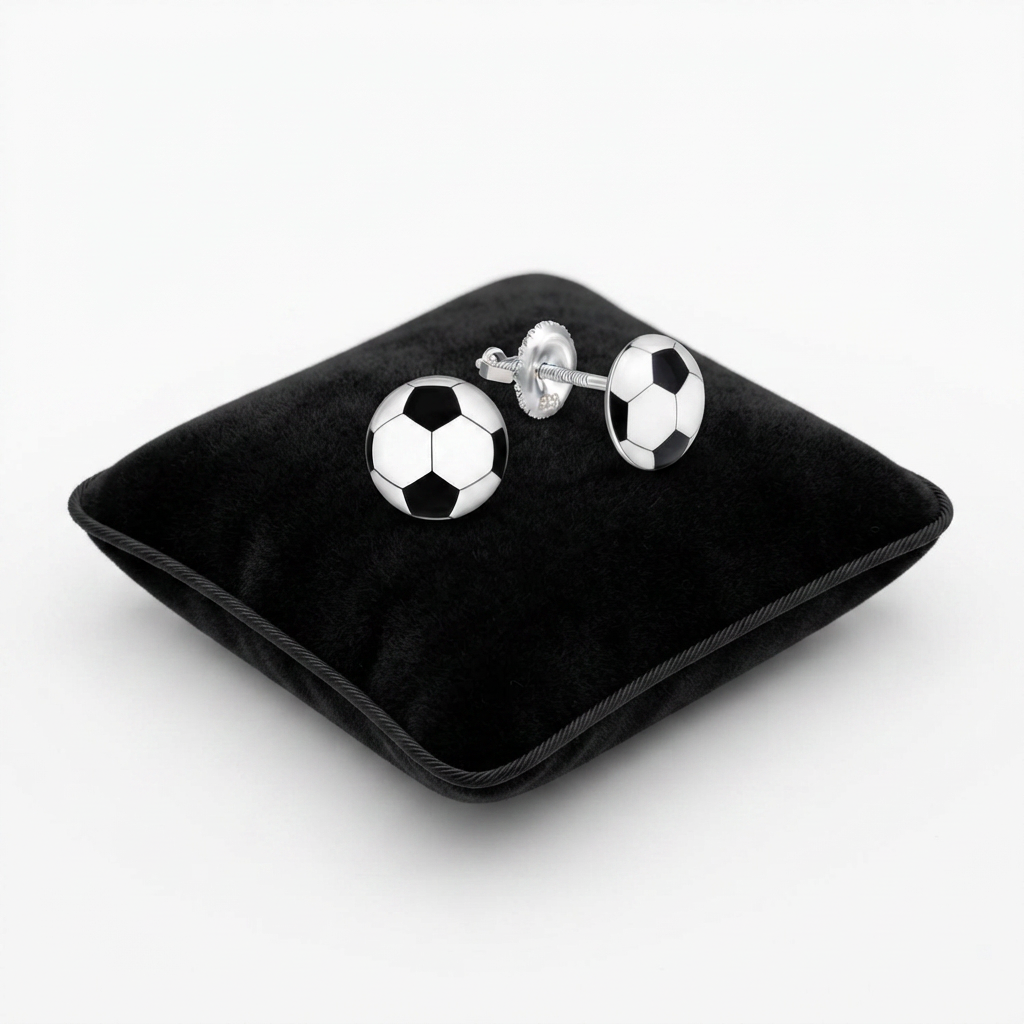 A pair of silver soccer ball cufflinks displayed on a black velvet cushion against a white background.