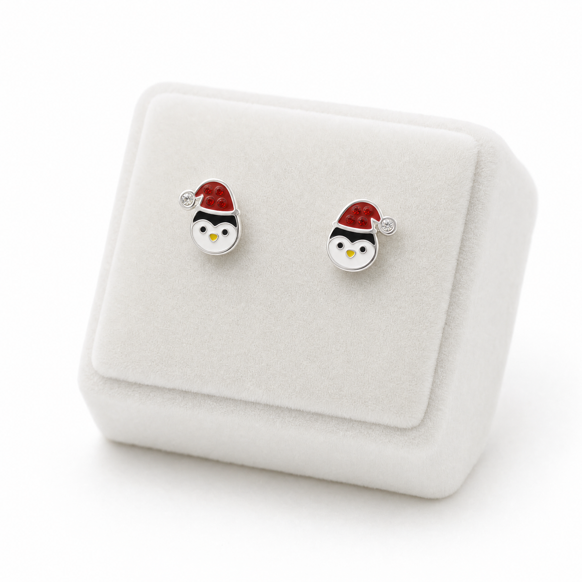 A pair of silver stud earrings shaped like penguins wearing red Santa hats