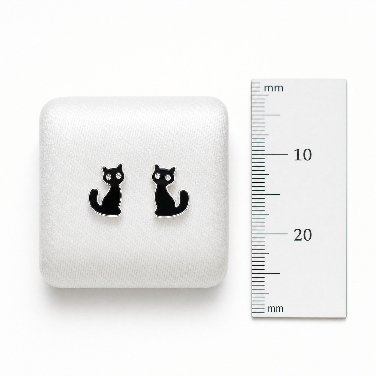 Girls’ sterling silver black crystal cat stud earrings on cushion showing size