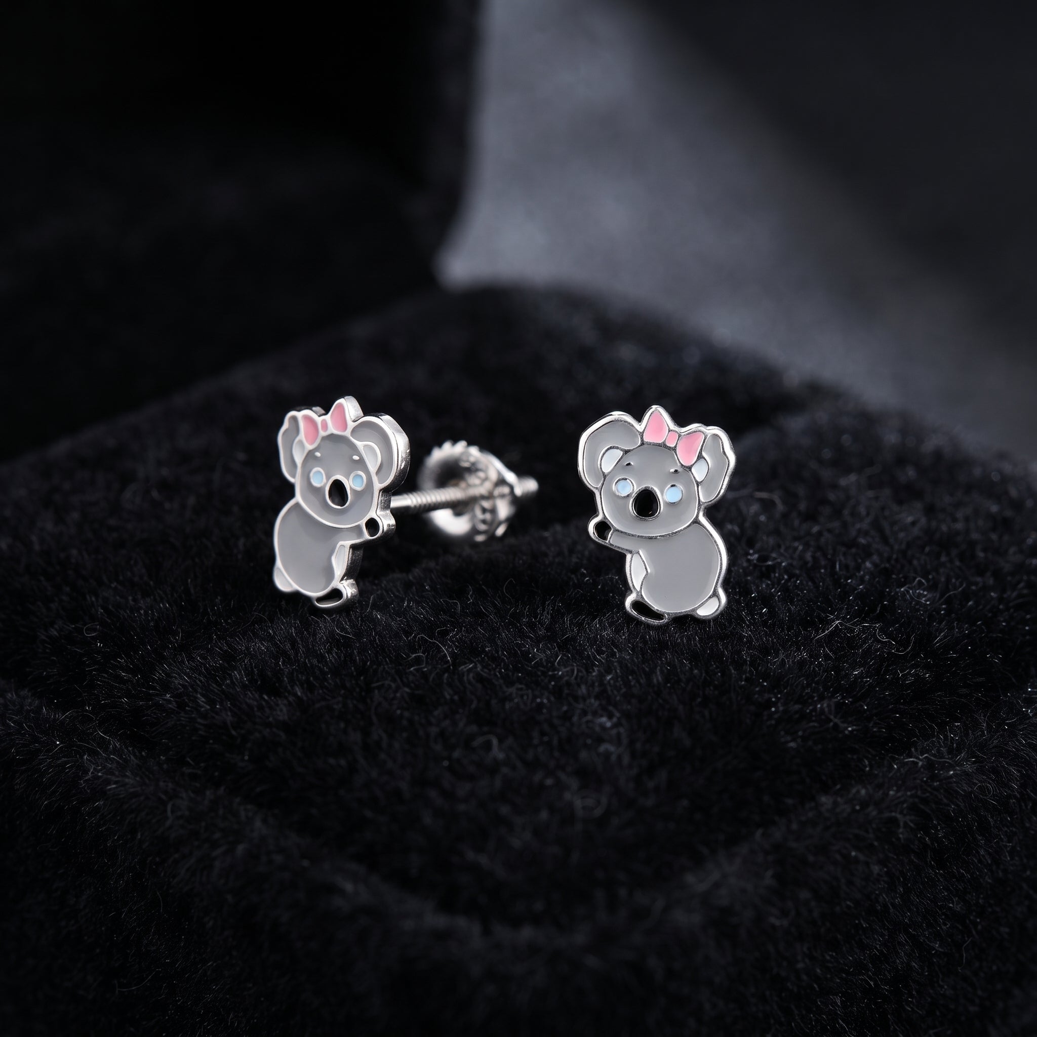 Pair of sterling silver koala screw back earrings with pink bow on dark velvet showing screw back fitting