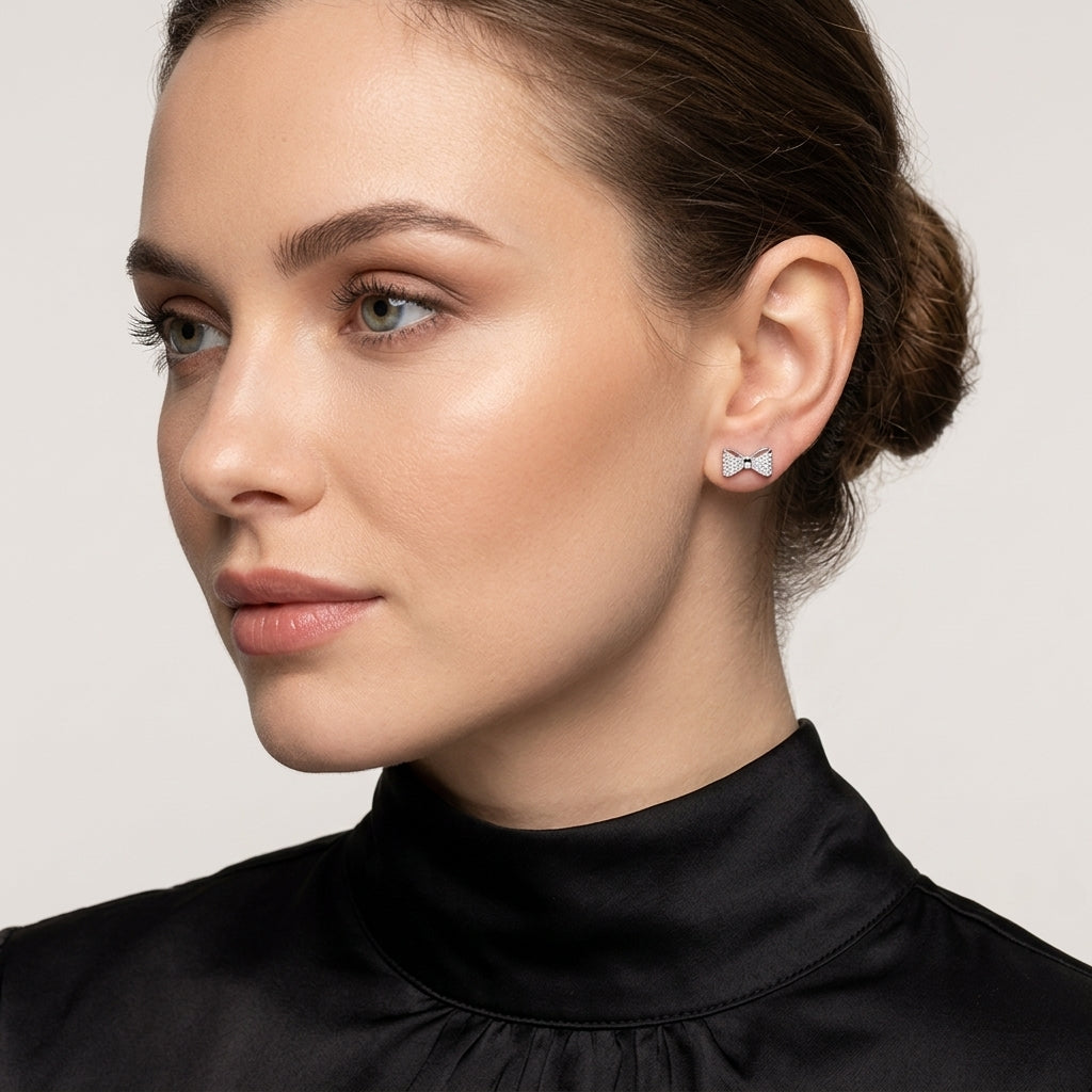 Melchior Jewellery Sterling Silver Pave Bow Earrings in shiny silver worn by woman with black top