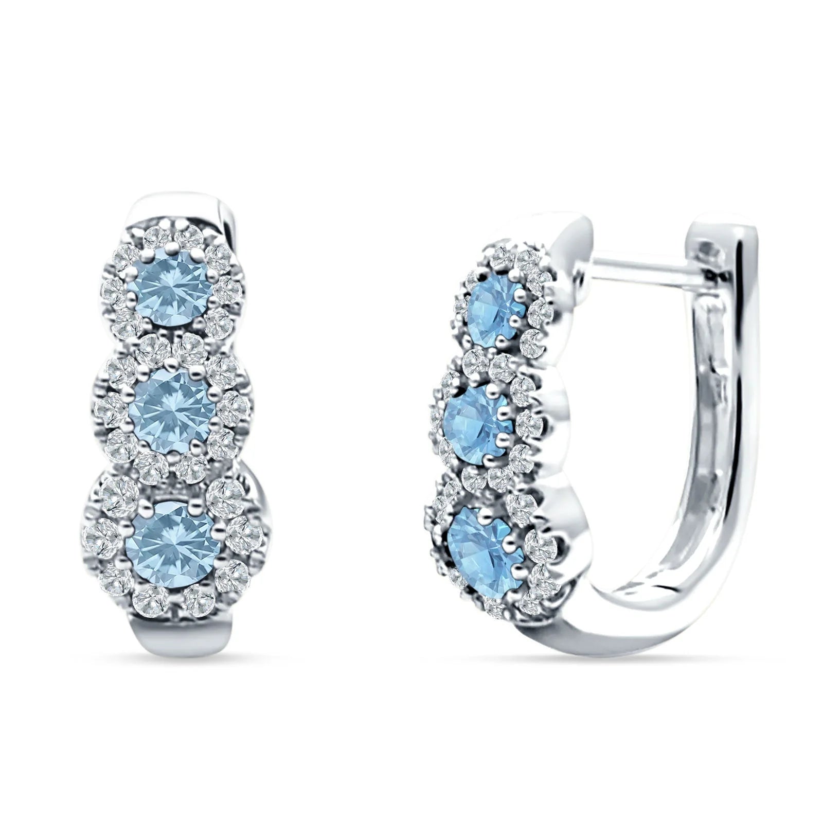 Melchior Jewellery silver huggie hoop earrings featuring three sky blue gemstones each surrounded by small clear crystals