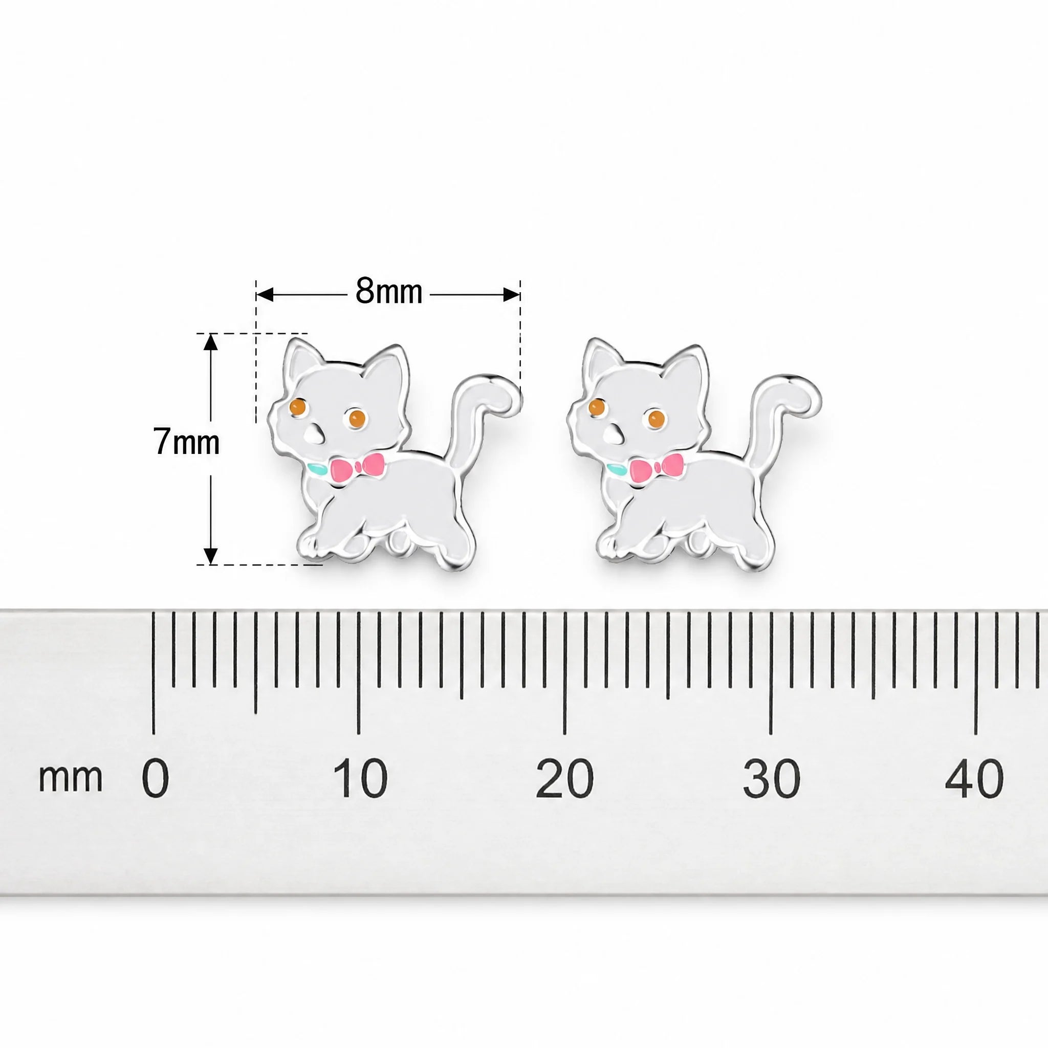 Two small white cat-shaped stud earrings with pink bow ties and orange eyes, shown beside a ruler with dimension markings indicating 8mm width and 7mm height.