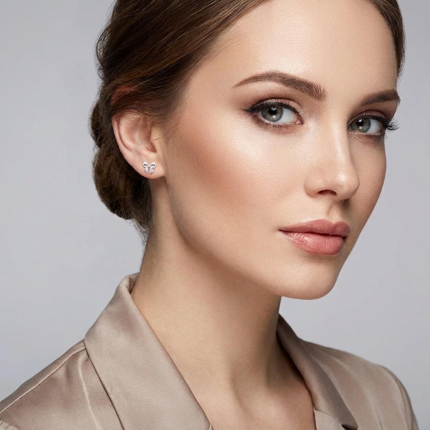 Sentiell sterling silver bow stud earrings worn by woman with natural makeup and beige blouse