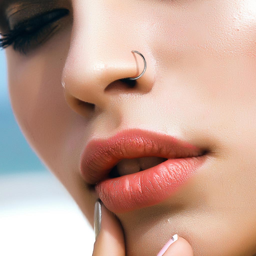 Close-up of a model wearing a silver implant grade nose ring from Melchior Jewellery on the left nostril