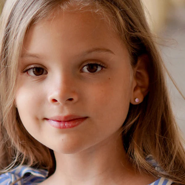 In Season Jewellery girls screw back earrings small pink stone studs worn by smiling girl
