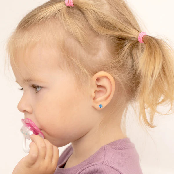 Child wearing children's sterling silver blue earrings with pink hair ties and purple top