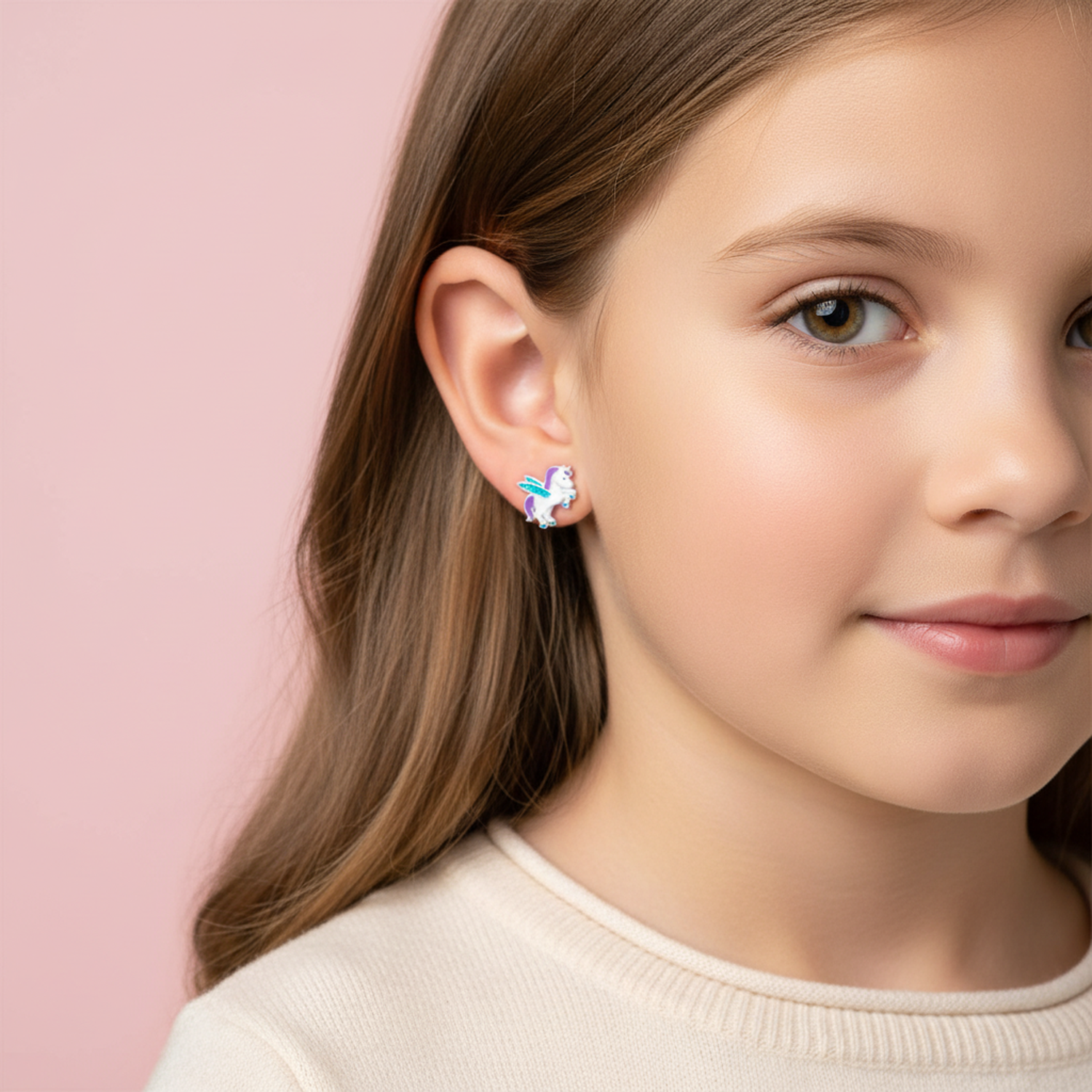 Melchior Jewellery kids winged unicorn screw back earrings worn by a young girl with brown hair
