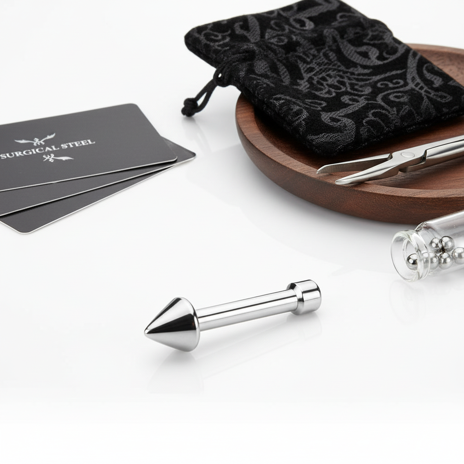 316L surgical steel nose stud with cone design by Melchior Jewellery on white surface with pouch and tools