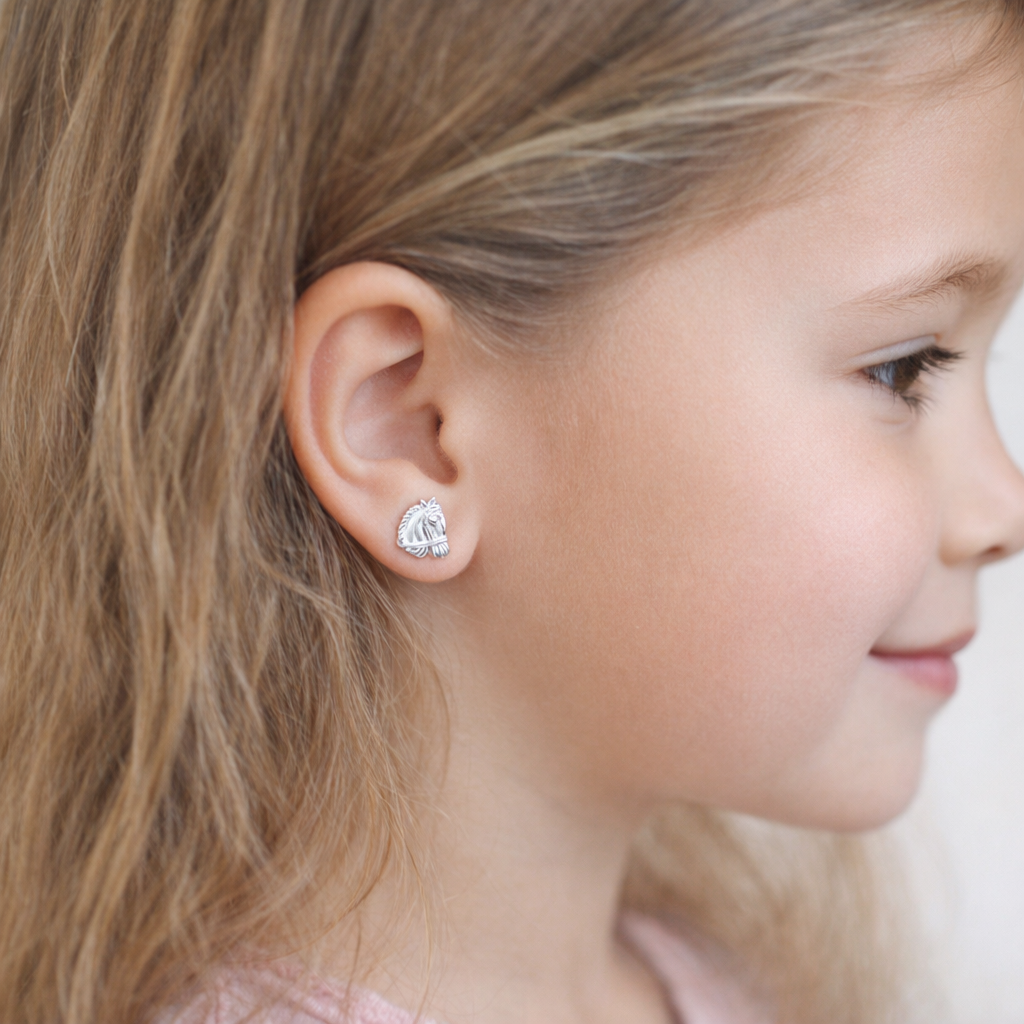 Childrens Sterling Silver Horse Stud Earrings worn by young girl with light brown hair and soft pink top