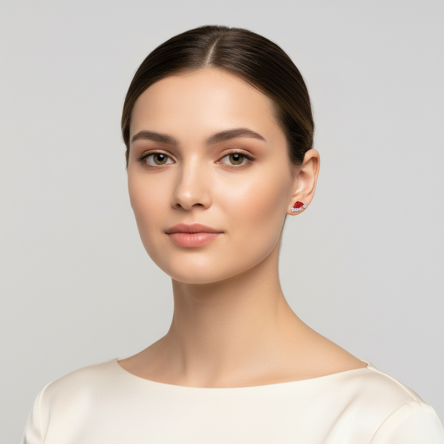 Melchior Jewellery Christmas Hat Earrings in red and white worn by model with smooth brown hair and cream top
