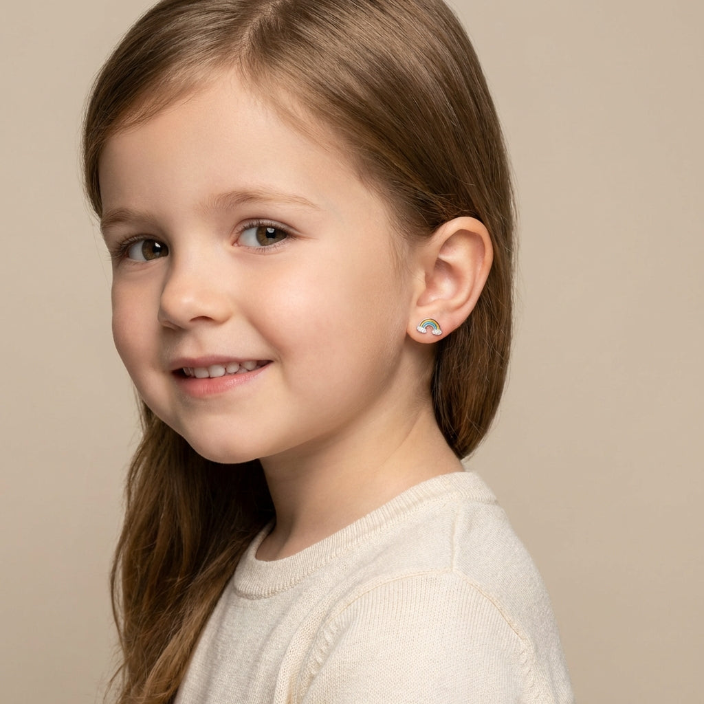 Child wearing colourful rainbow stud earrings girls by Melchior Jewellery with a beige top