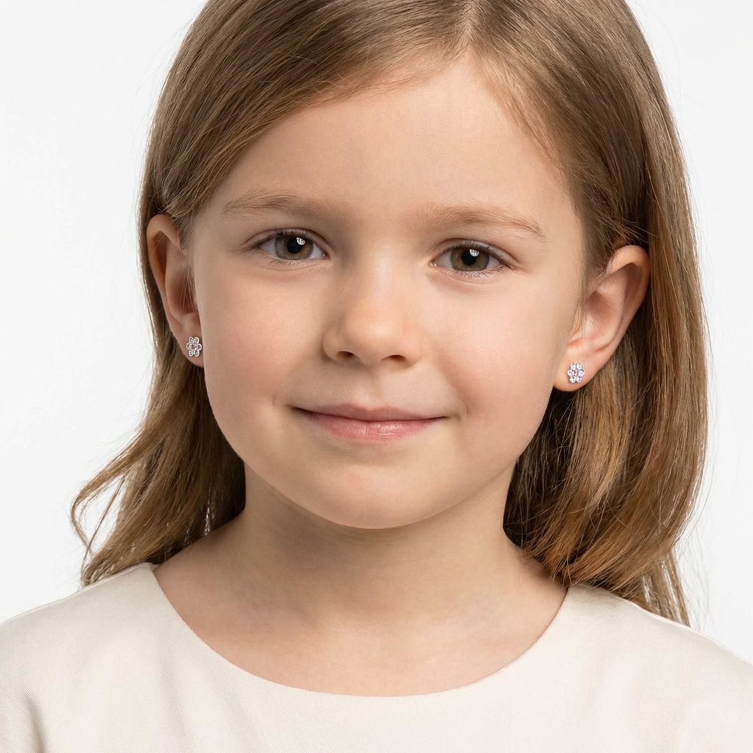 Young girl wearing Melchior Jewellery crystal flower earrings for girls with a gentle smile