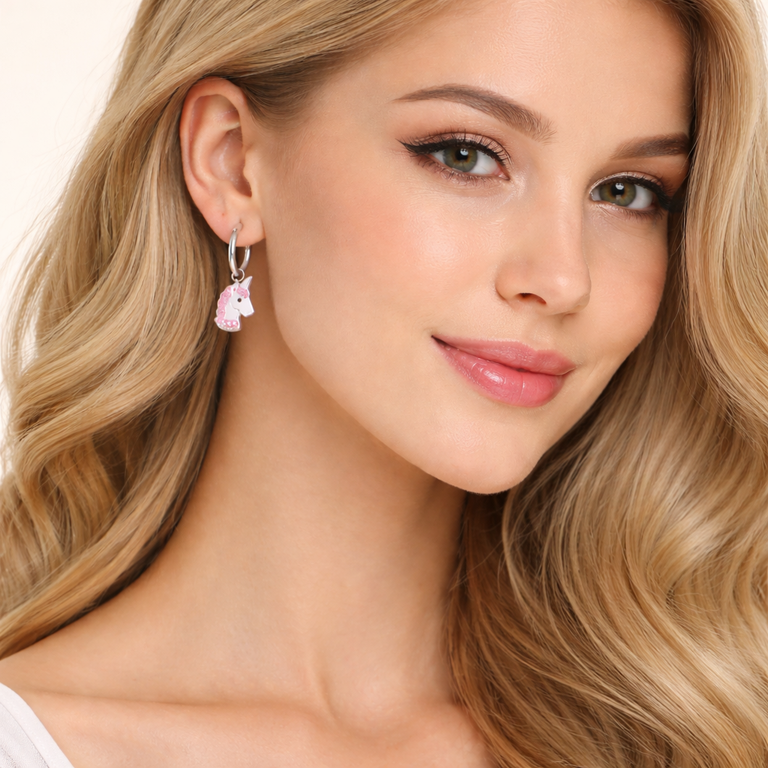 Crystal unicorn earrings for girls by Melchior Jewellery worn on young woman's ear with pink and white details