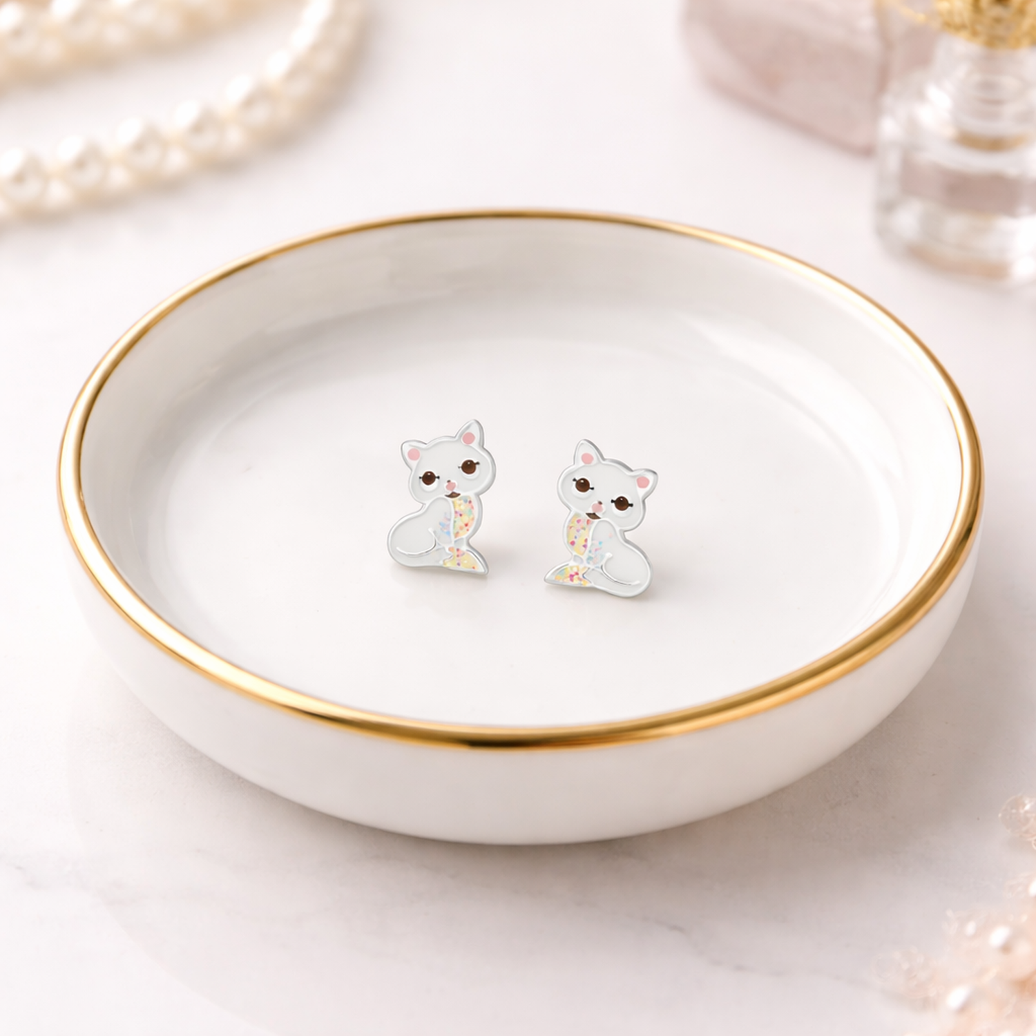 Melchior Jewellery cute cat stud earrings for kids displayed on a white dish with a gold rim