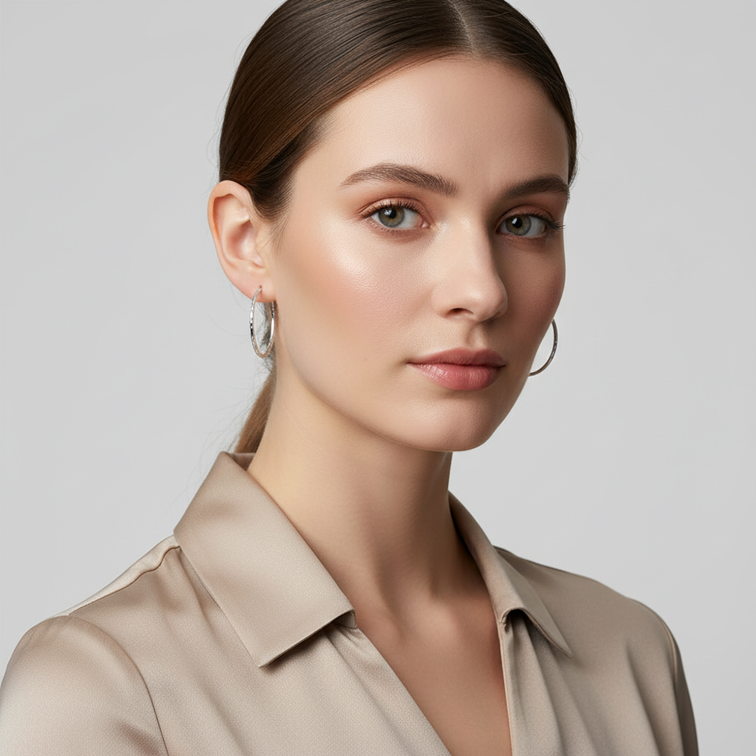 Melchior Jewellery diamond cut silver hoop earrings worn by woman with neutral blouse