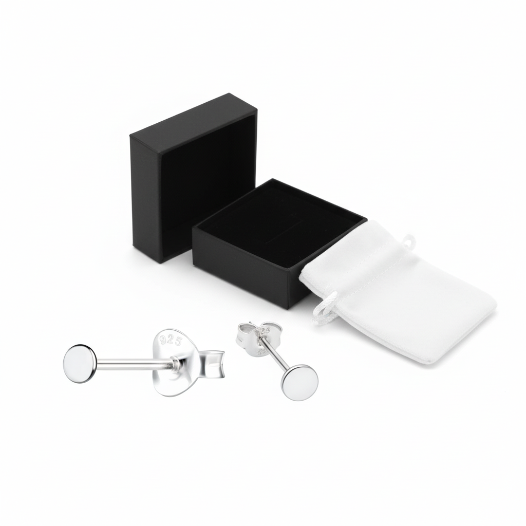 Flat round silver stud earrings by Melchior Jewellery displayed with black box and white pouch