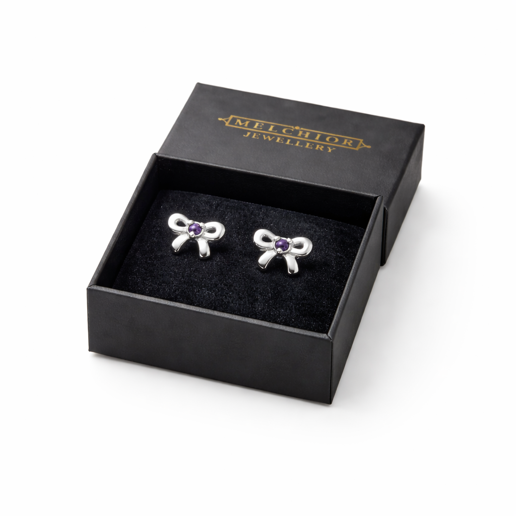 Melchior Jewellery girls amethyst birthstone earrings shaped like silver bows in black gift box