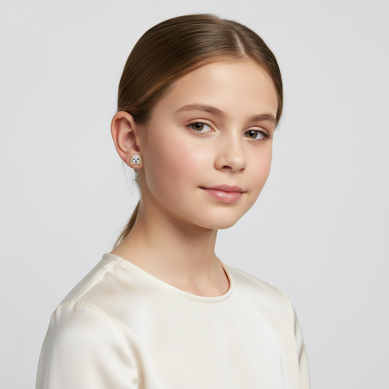 Young girl wearing Melchior Jewellery white and black enamel girls dog stud earrings with gold trim