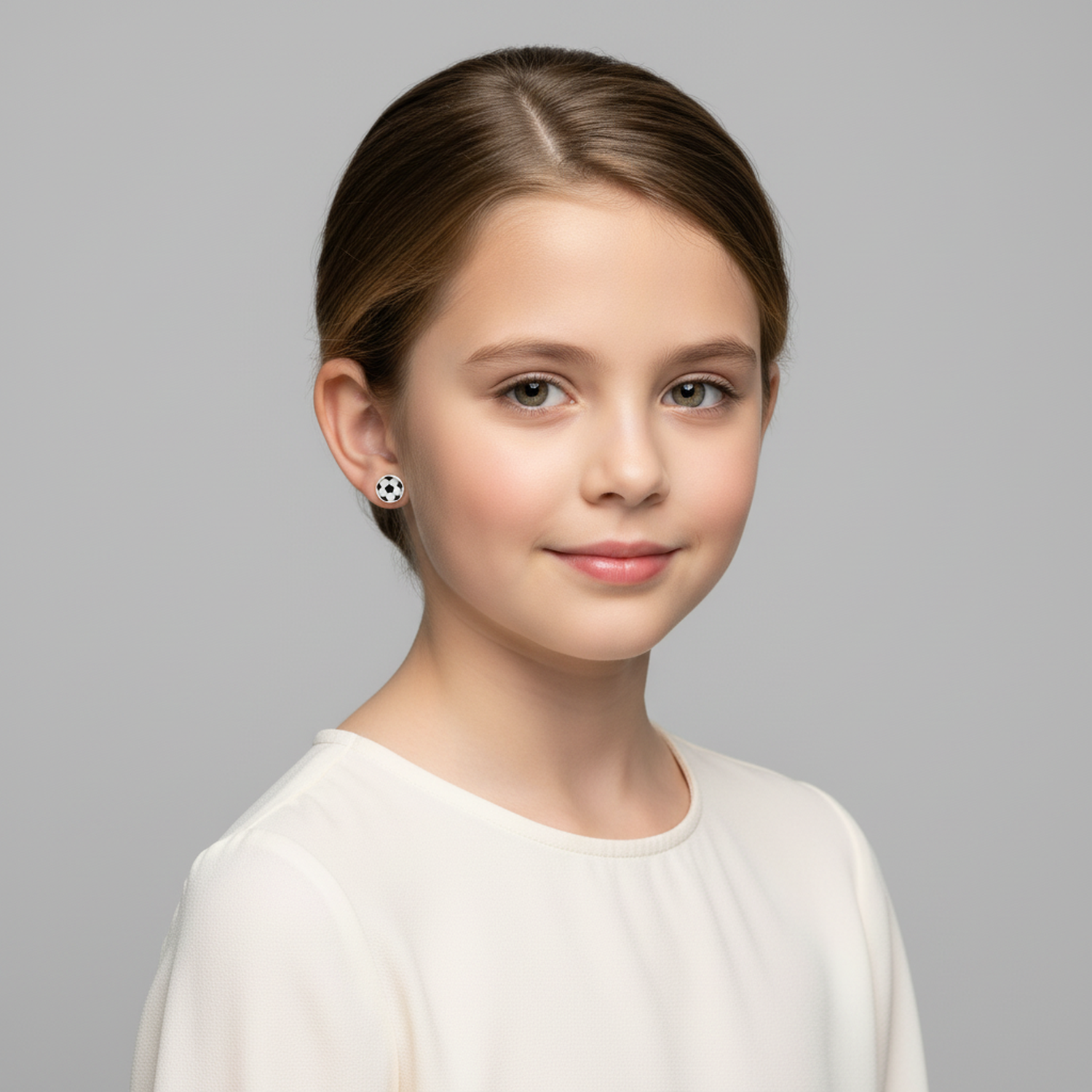 Melchior Jewellery girls football earrings sterling silver worn by young girl in white top