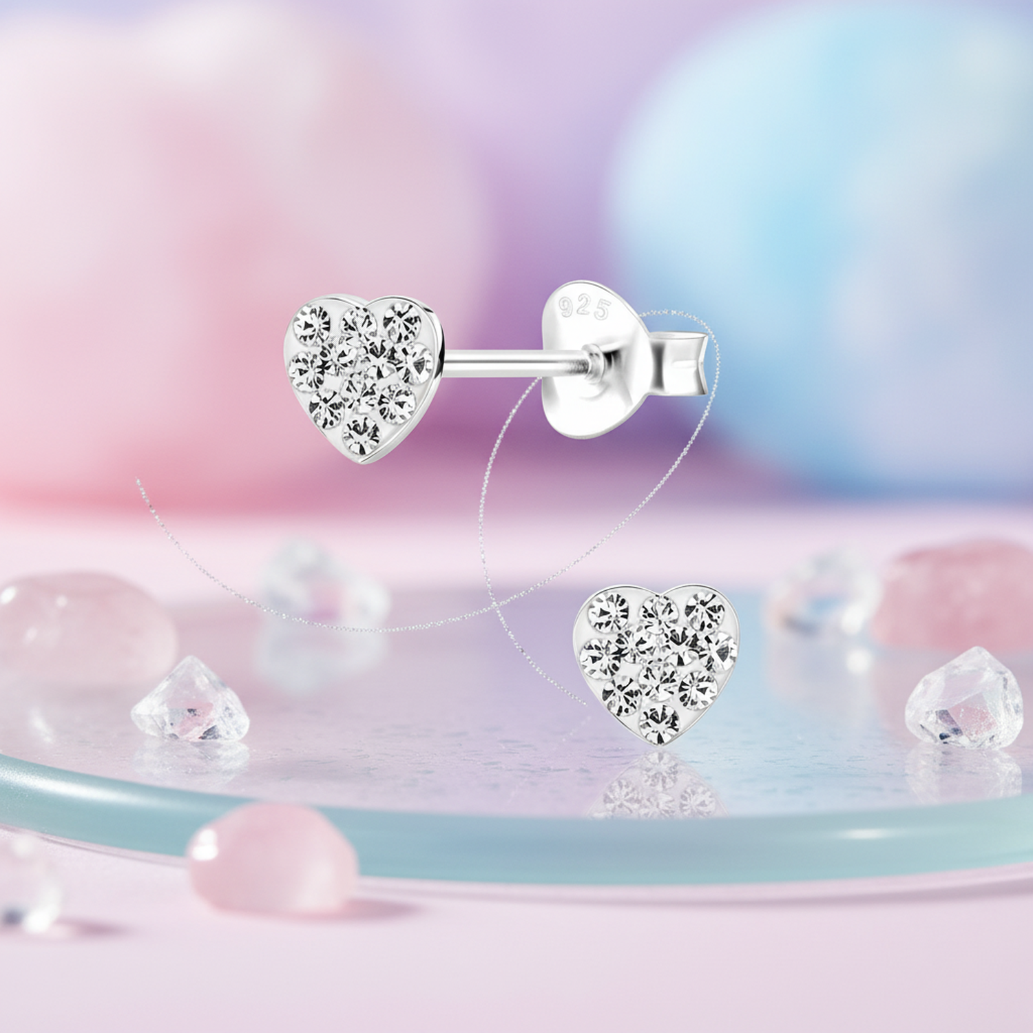 Melchior Jewellery silver girls heart earrings with sparkling clear crystals on soft pink and blue background