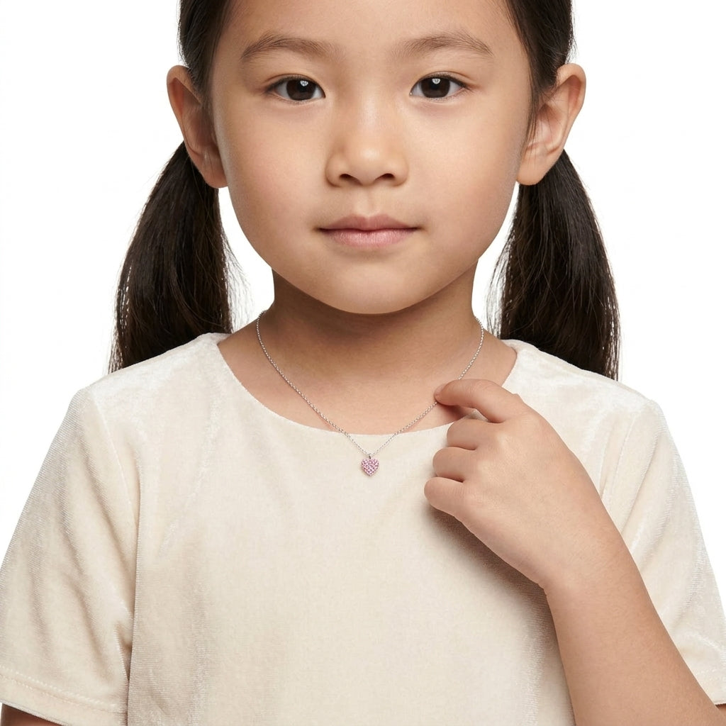 Young girl wearing Melchior Jewellery girls pink crystal heart necklace with silver chain and light pink crystals