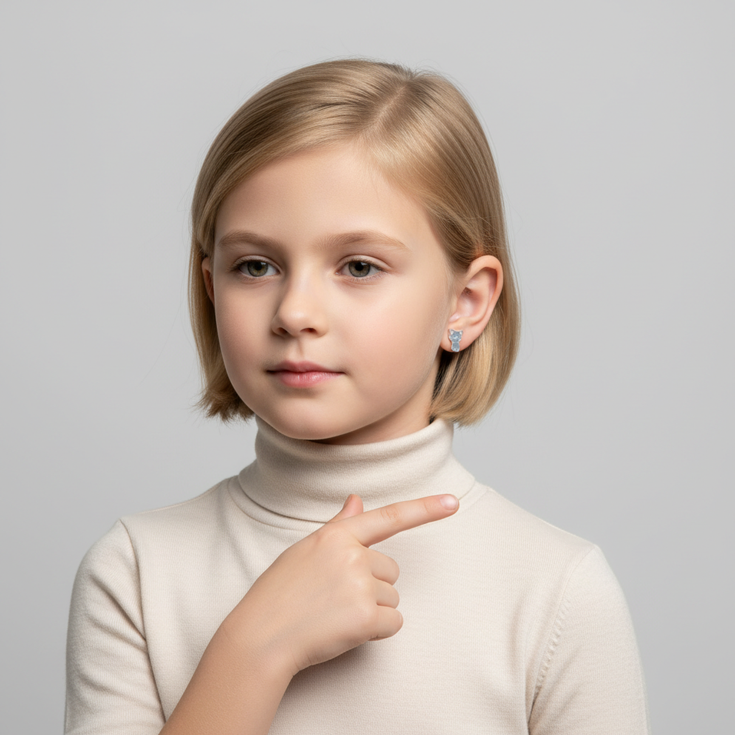 Hypoallergenic kids cat stud earrings worn by girl with short blonde hair in cream turtleneck
