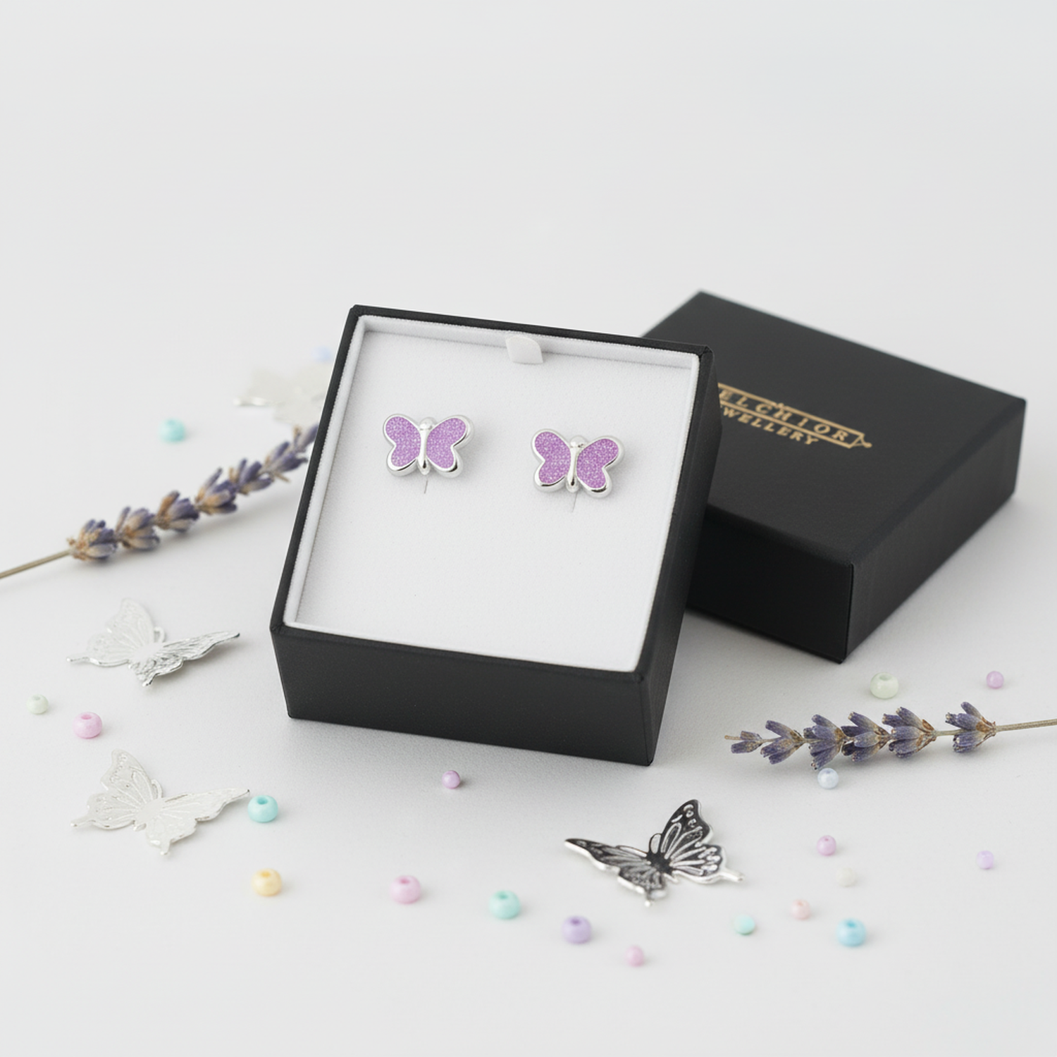Purple glitter butterfly stud earrings for kids by Melchior Jewellery in a black gift box with decorative butterflies and beads