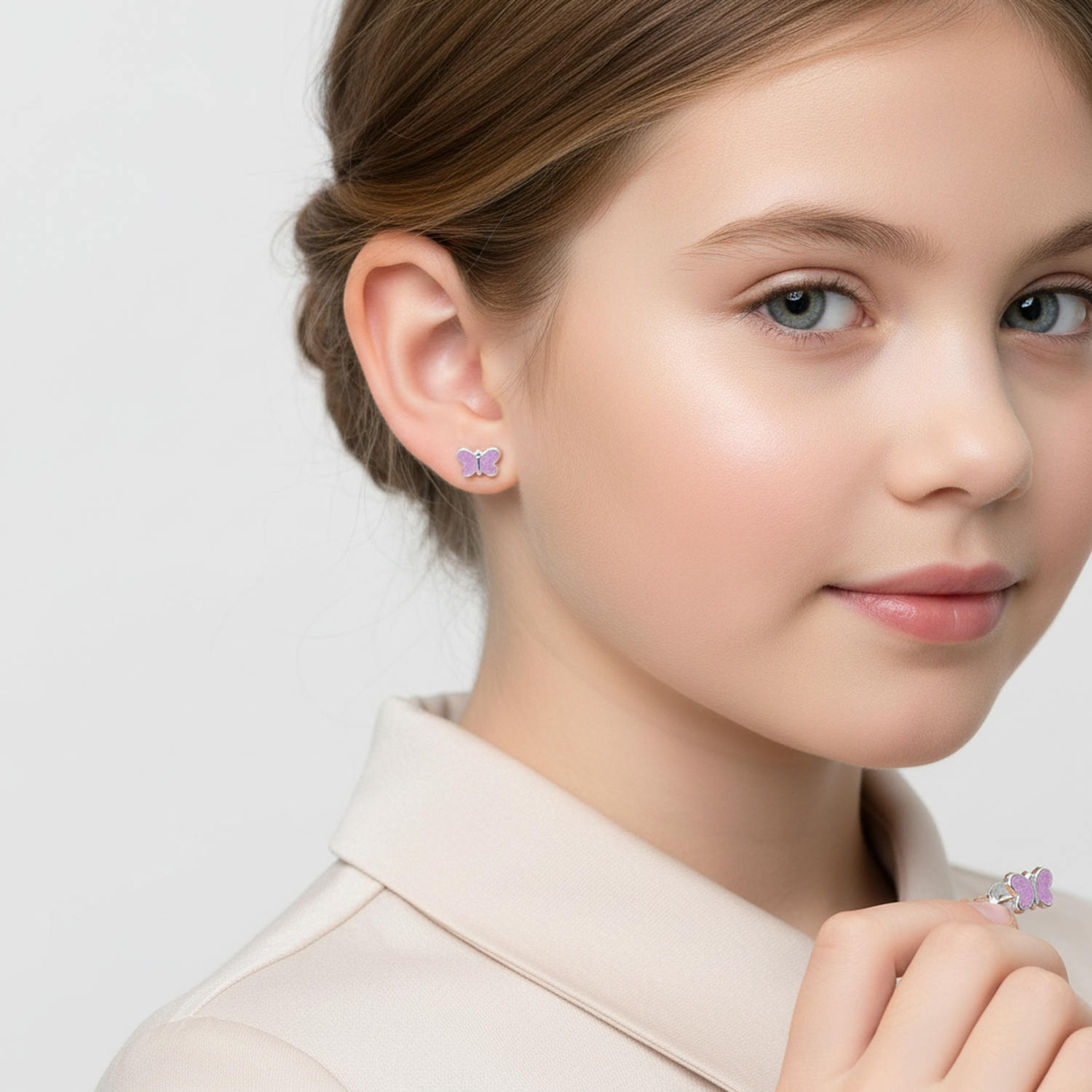 Purple glitter butterfly stud earrings for kids worn by a young girl with light brown hair