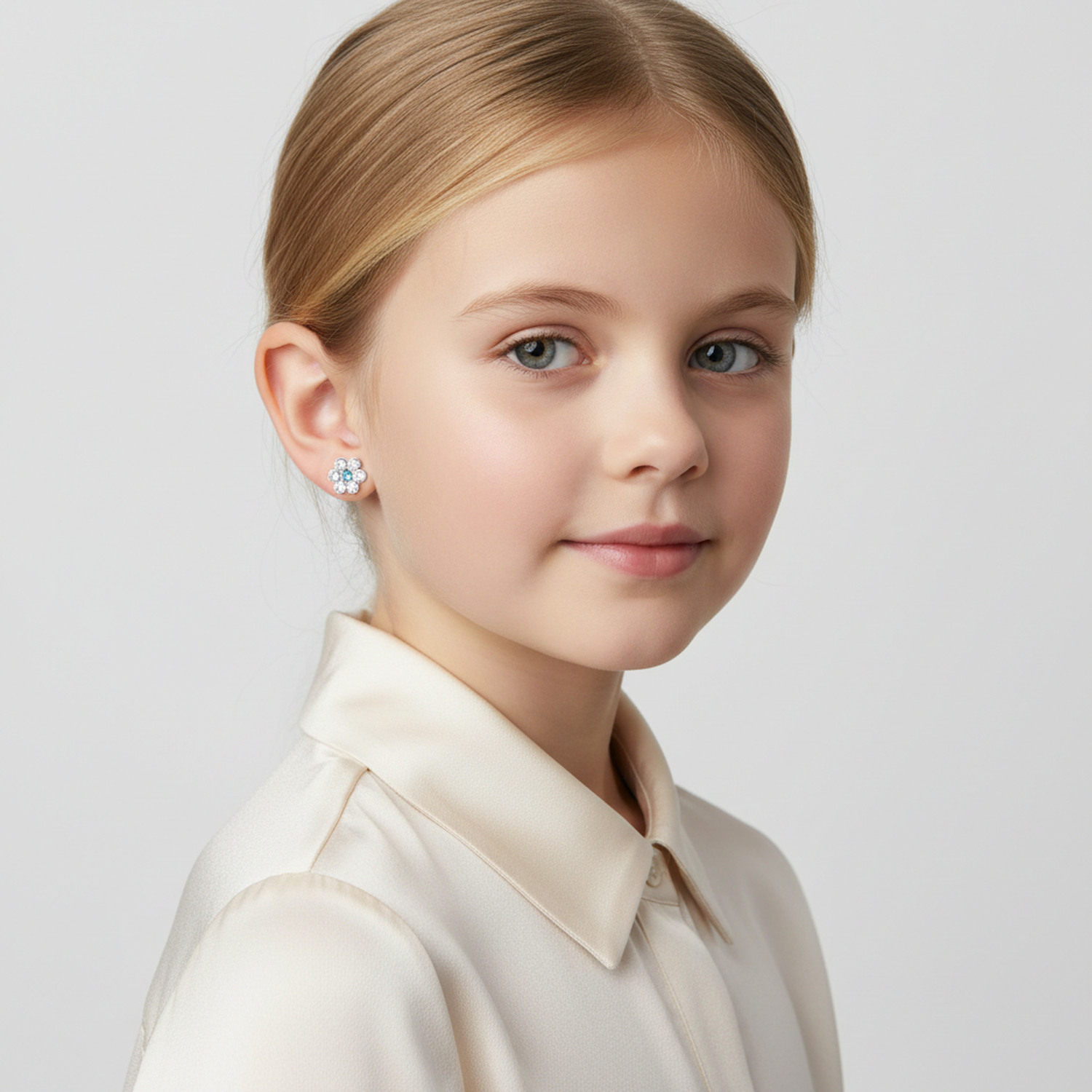 Young girl wearing Melchior Jewellery kids crystal stud earrings hypoallergenic with a white shirt