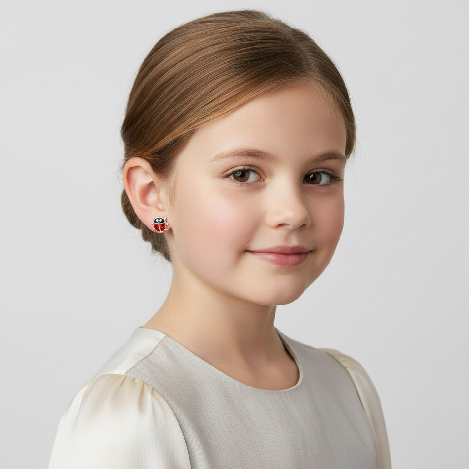 Young girl wearing kids hypoallergenic ladybird studs from Melchior Jewellery, perfect for sensitive ears