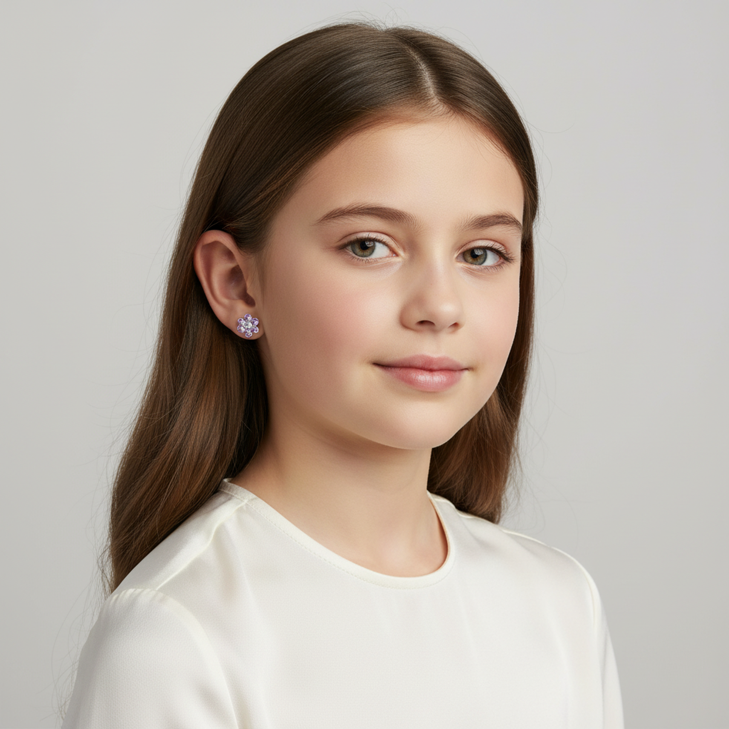 Young girl wearing kids lilac flower stud earrings from Melchior Jewellery in a white top