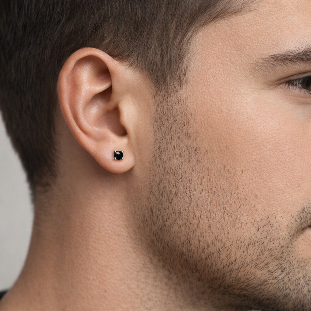 Mens sterling silver black stud earring worn on ear with close-up of skin texture