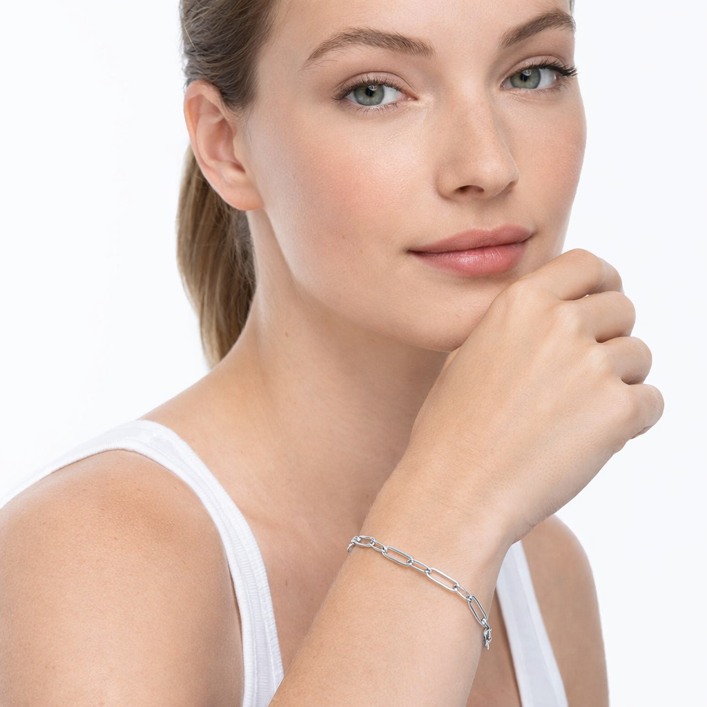 Silver Paperclip Chain Bracelet by Melchior Jewellery worn on wrist of woman in white top