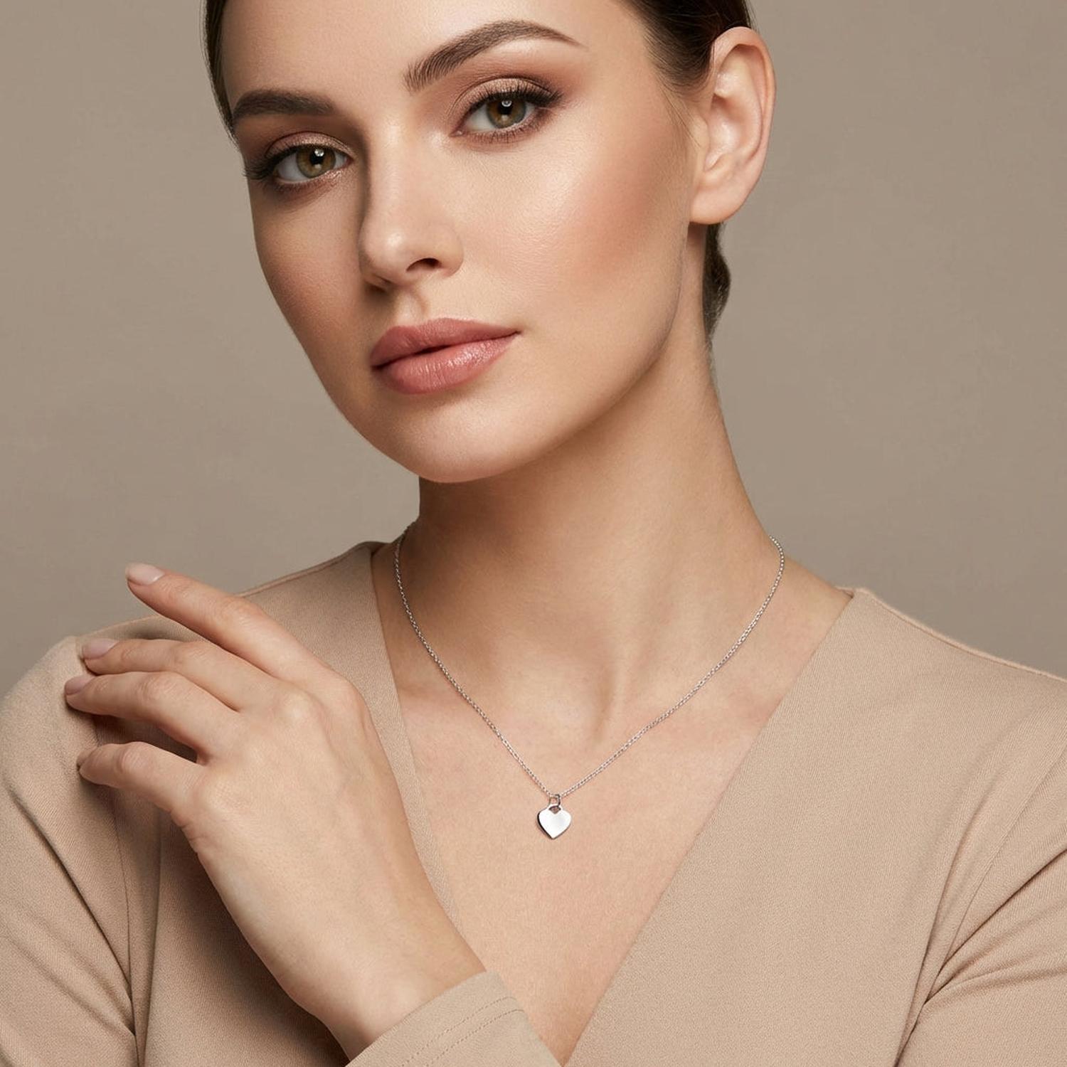 Woman wearing plain flat heart necklace for woman by Melchior Jewellery with a simple silver chain