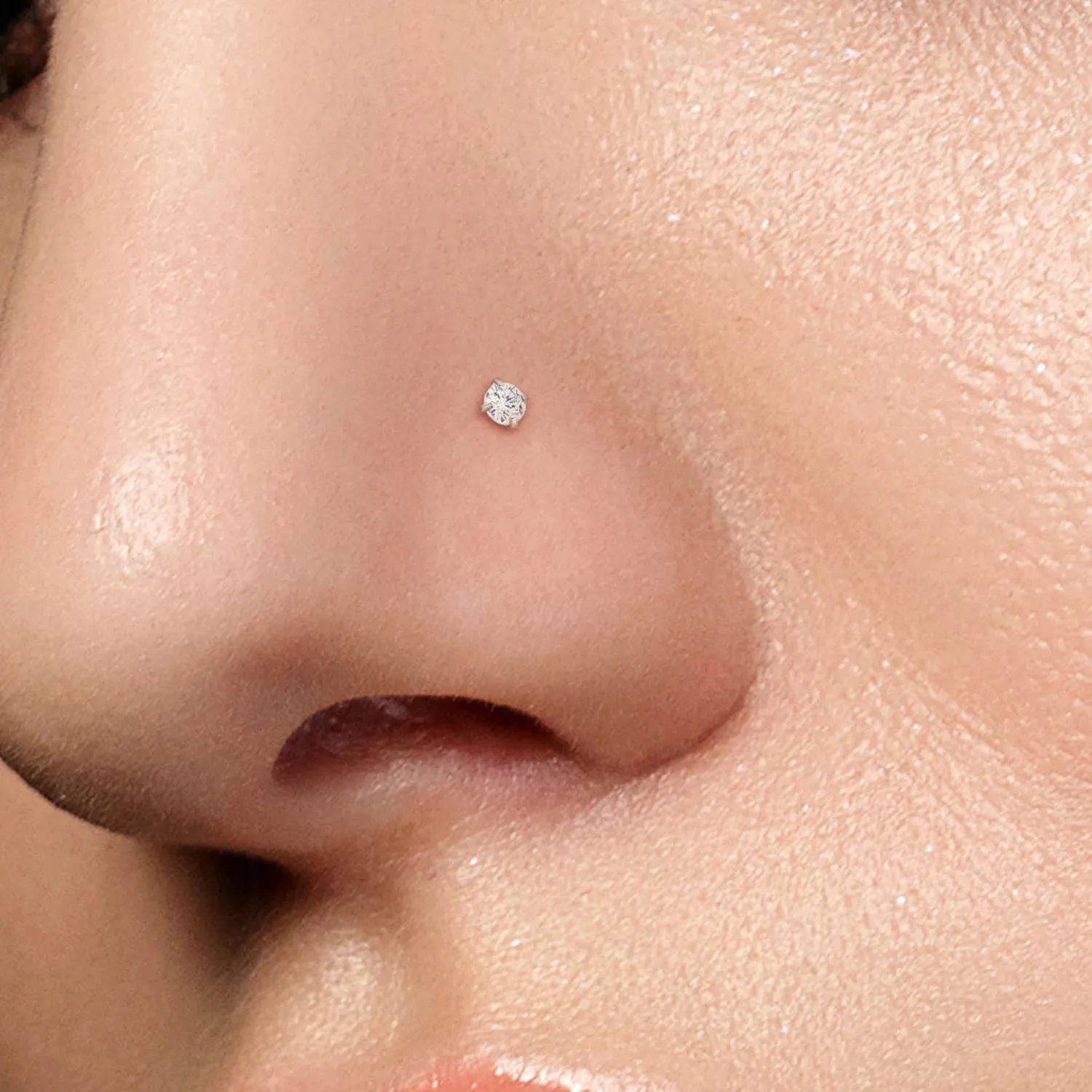 Melchior Jewellery prong set nose stud for piercing on model nostril close up small sparkling gem