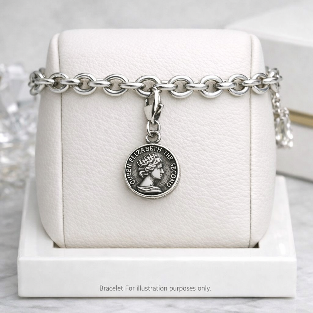 Silver Queen Elizabeth Charm pendant on a thick silver chain bracelet by Melchior Jewellery displayed on white cushion