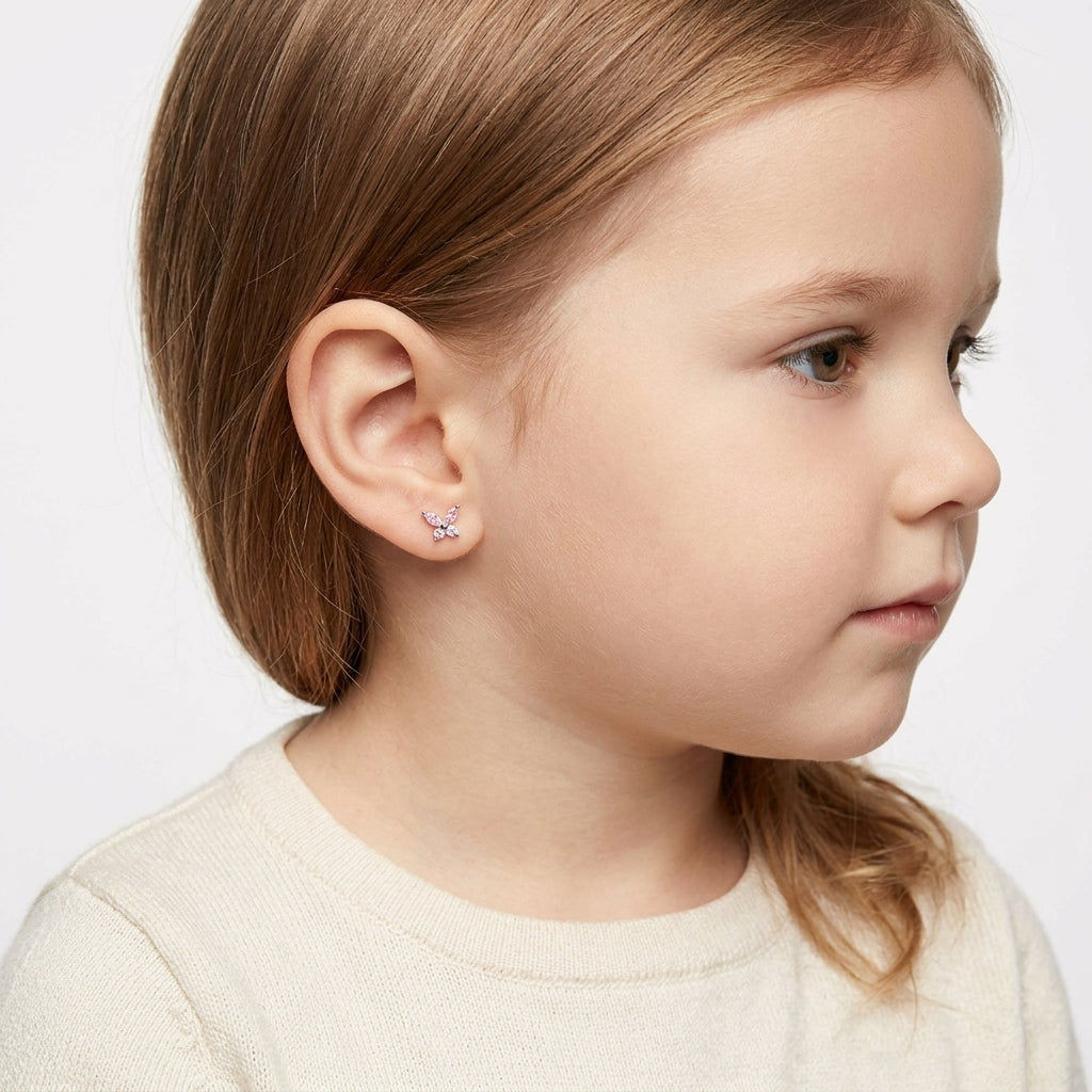 Melchior Jewellery pink butterfly screw back earrings for girls worn by a young girl with light brown hair