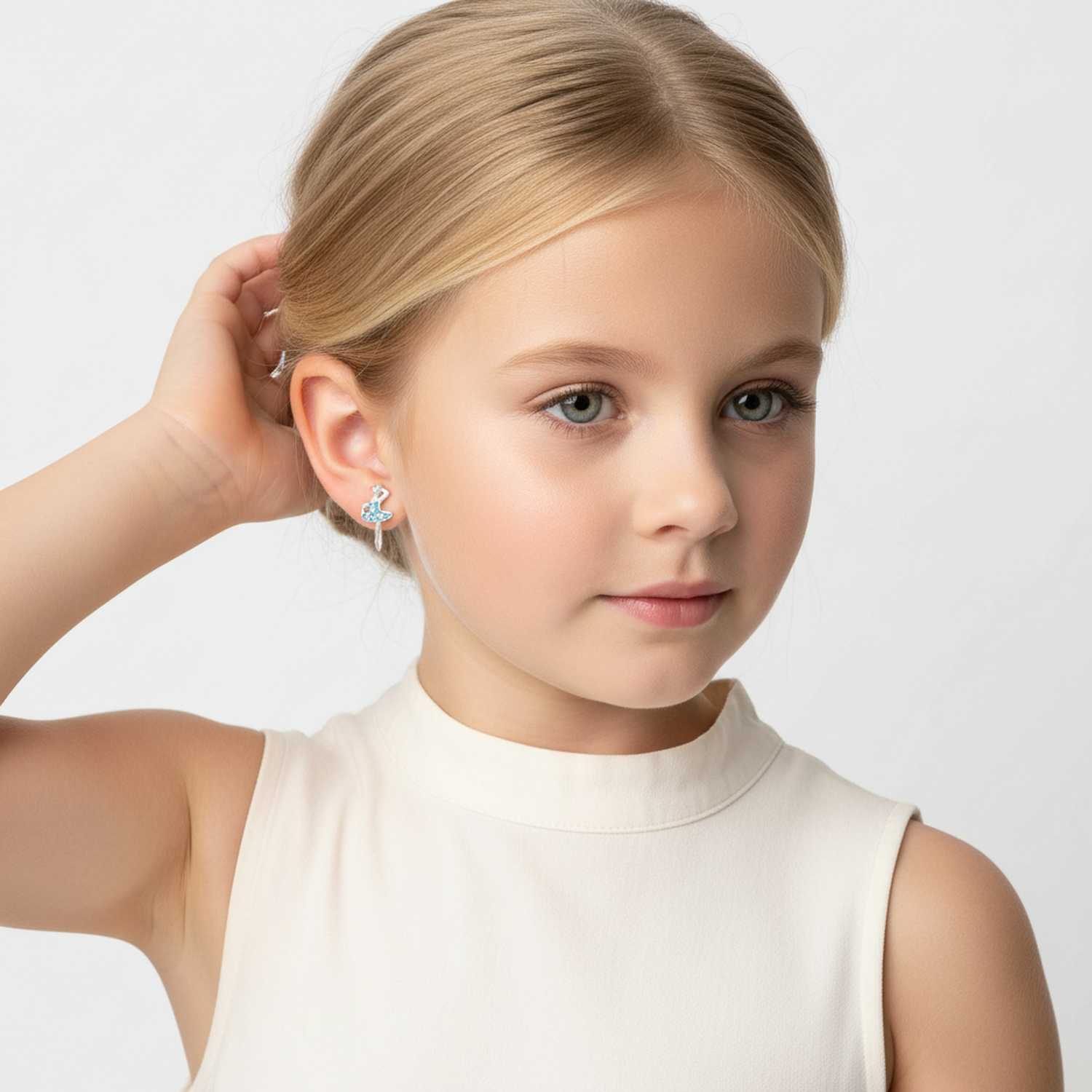 Young girl wearing silver ballet earrings for girls from Melchior Jewellery with blue stone detail