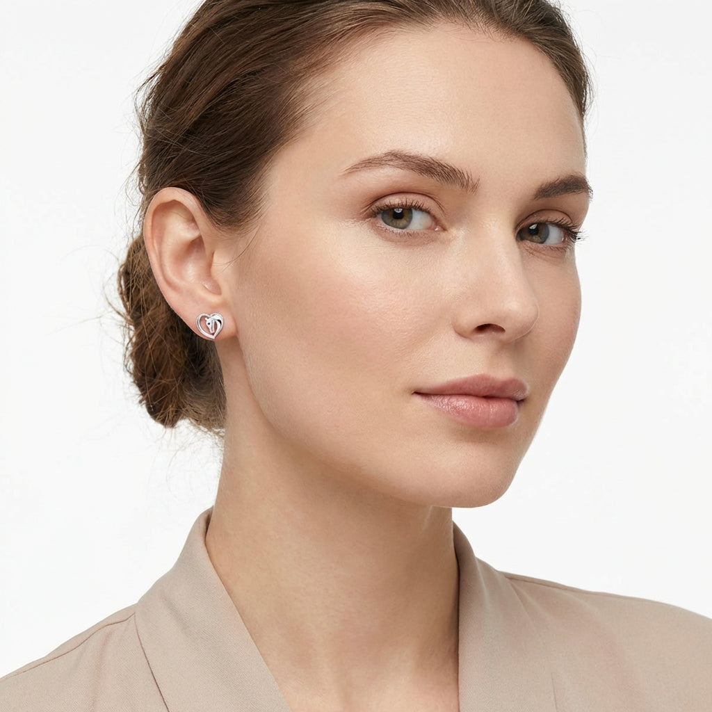 Melchior Jewellery silver heart horse earrings worn by woman with natural makeup and beige blouse