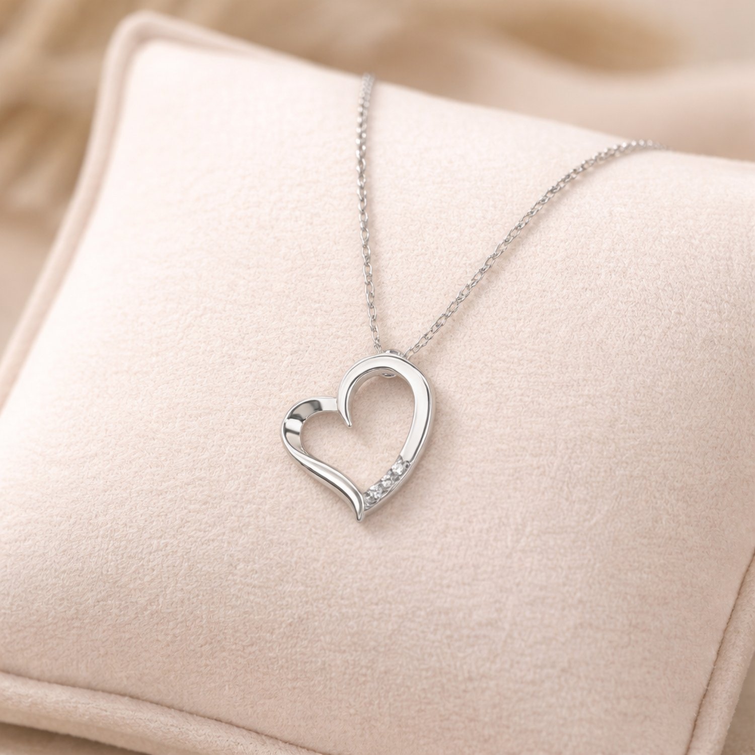 Melchior Jewellery silver open heart pendant necklace displayed on a soft beige cushion