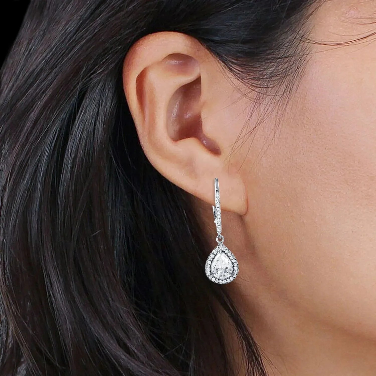 Melchior Jewellery silver pear halo leverback drop earrings worn on a woman's ear showcasing elegant design