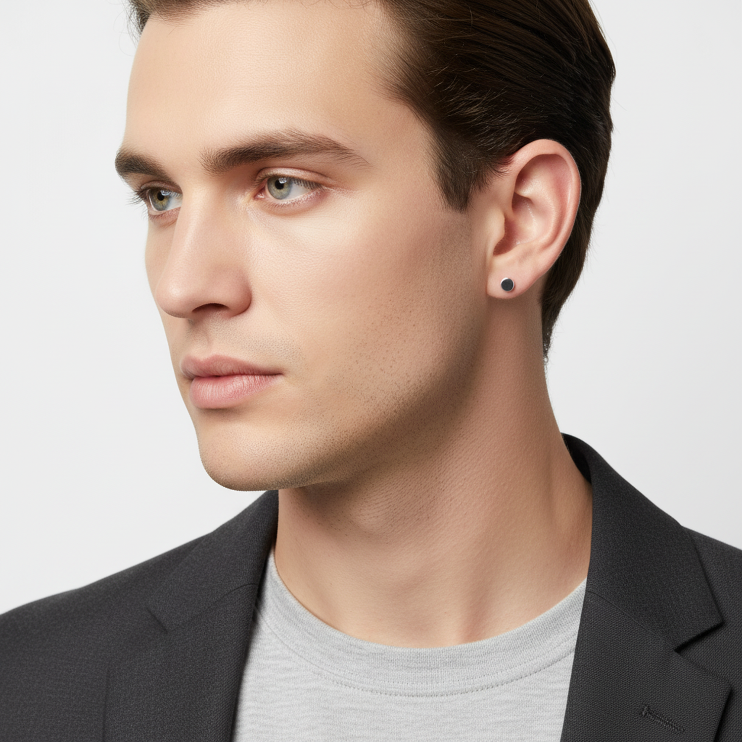 Melchior Jewellery single flat disc stud earring for men worn by a man with short brown hair and a black blazer