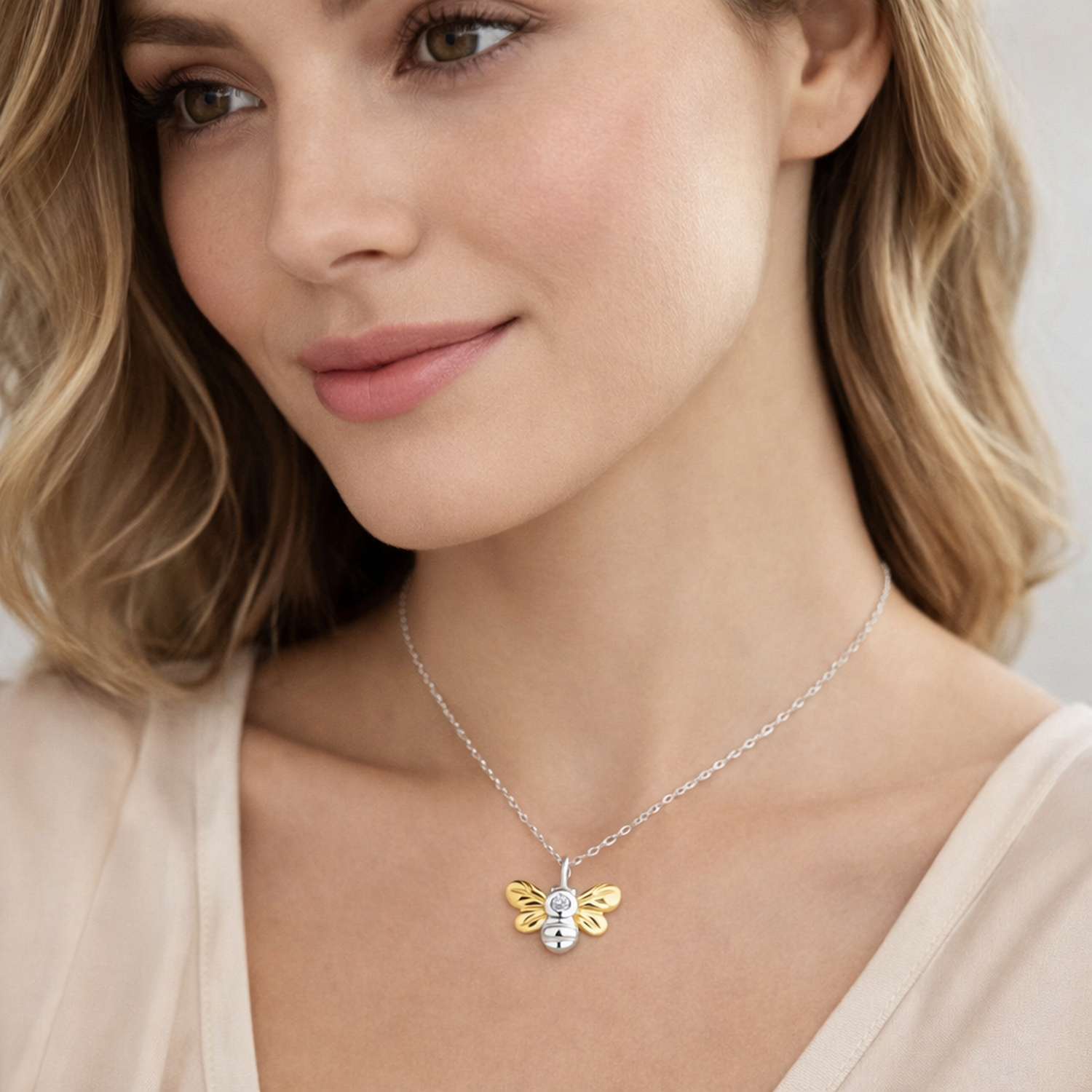 Melchior Jewellery sterling silver bee necklace with gold-tone wings worn by woman