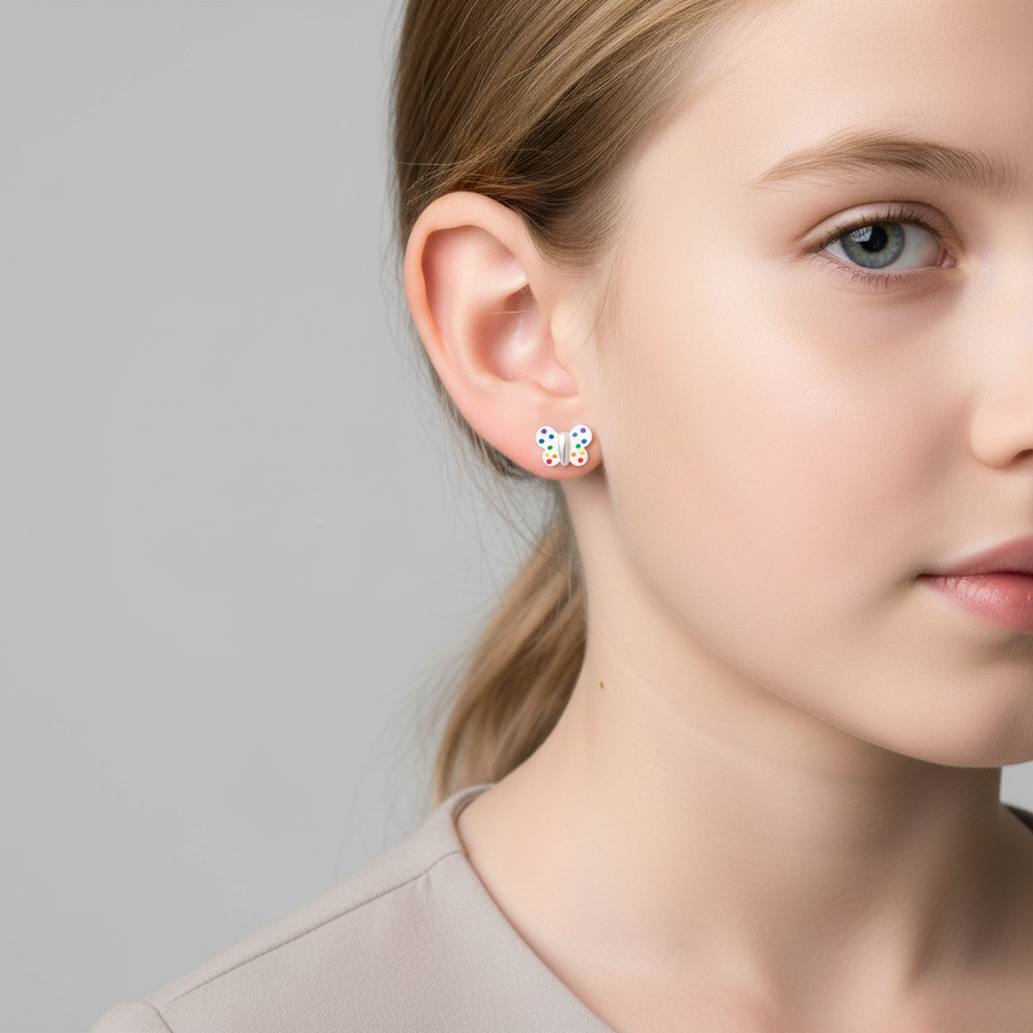 Sterling Silver Butterfly Earrings by Melchior Jewellery featuring colourful enamel dots worn on a young woman
