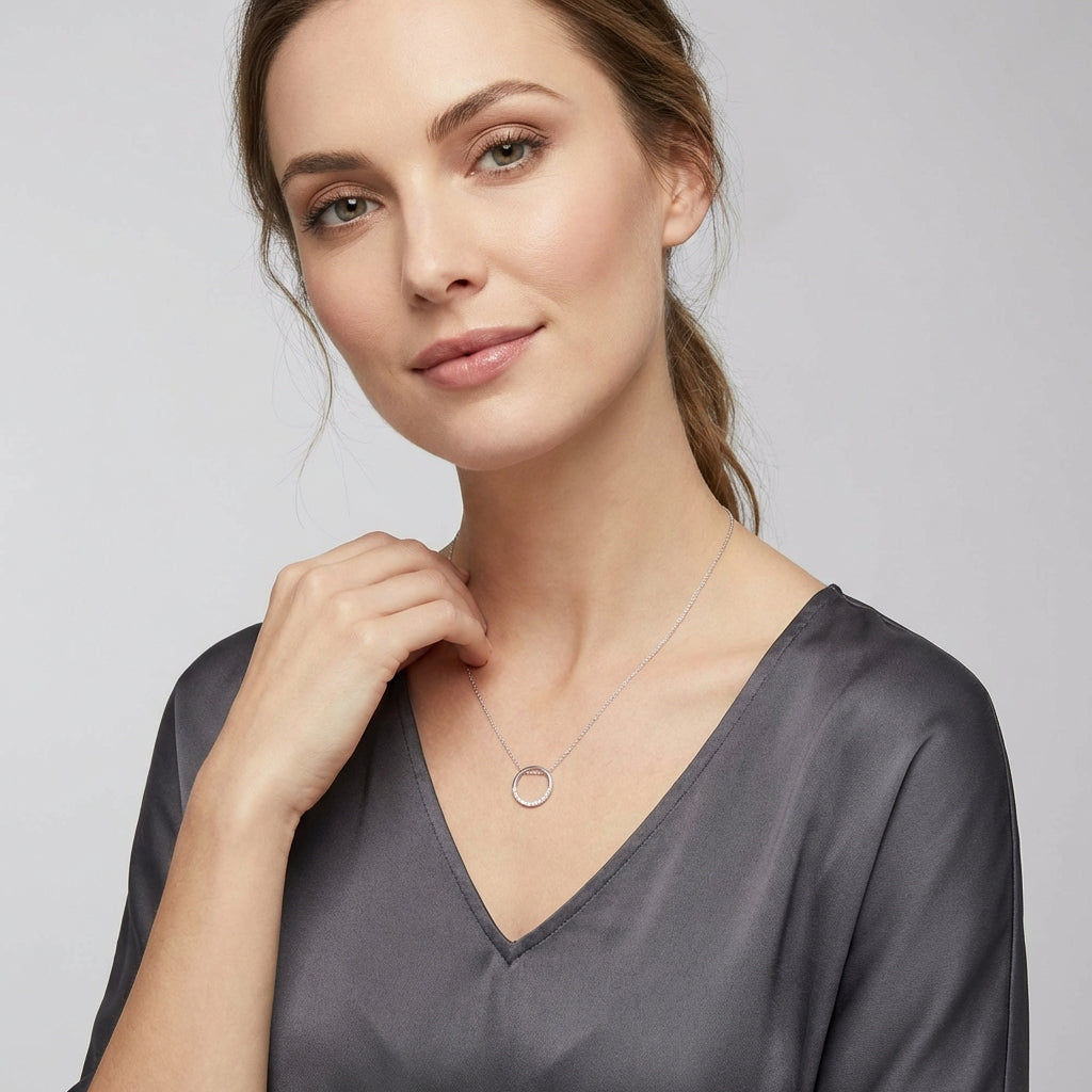 Melchior Jewellery sterling silver circle necklace worn by woman in grey satin blouse