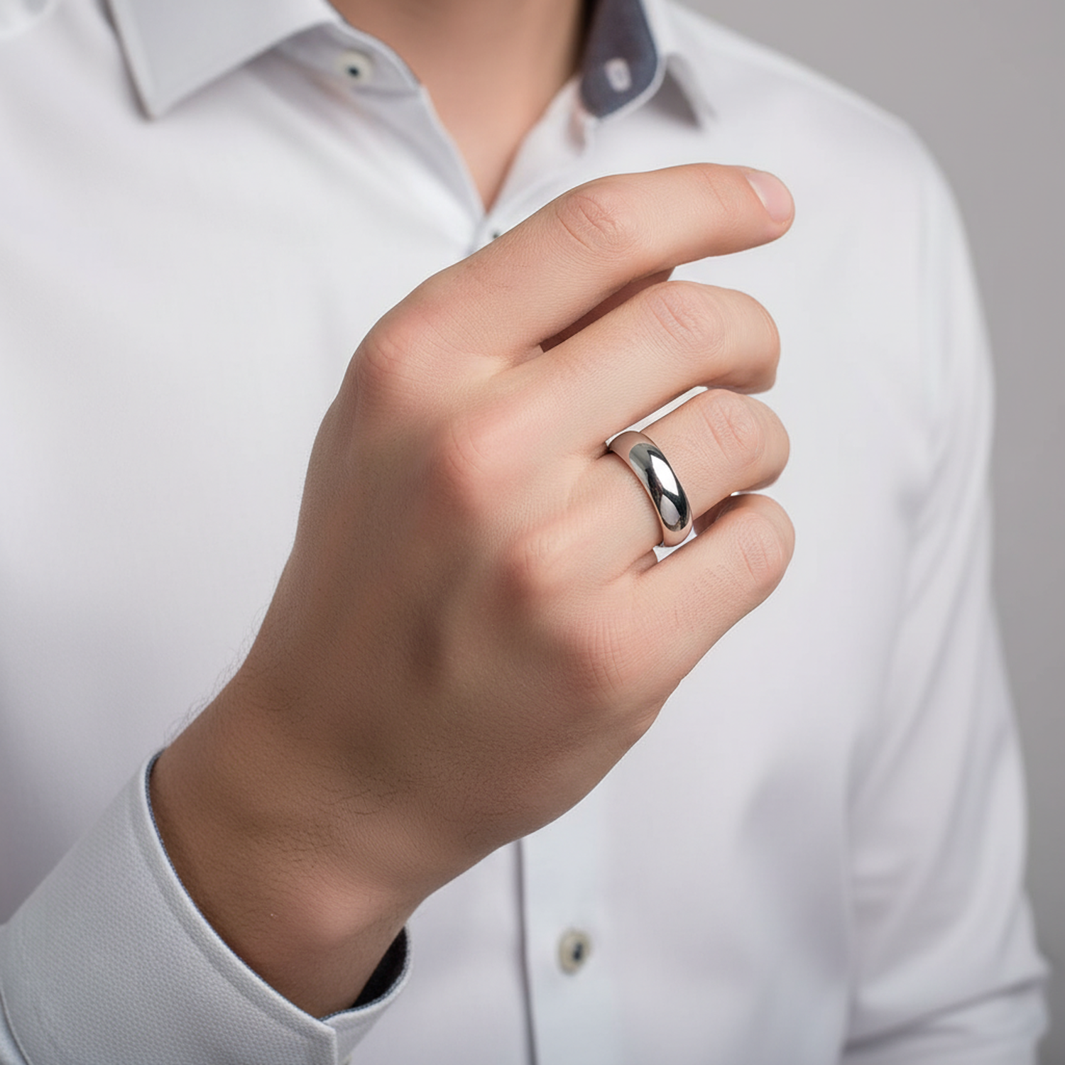Sterling silver d shape wedding ring by Melchior Jewellery worn on finger with white shirt background