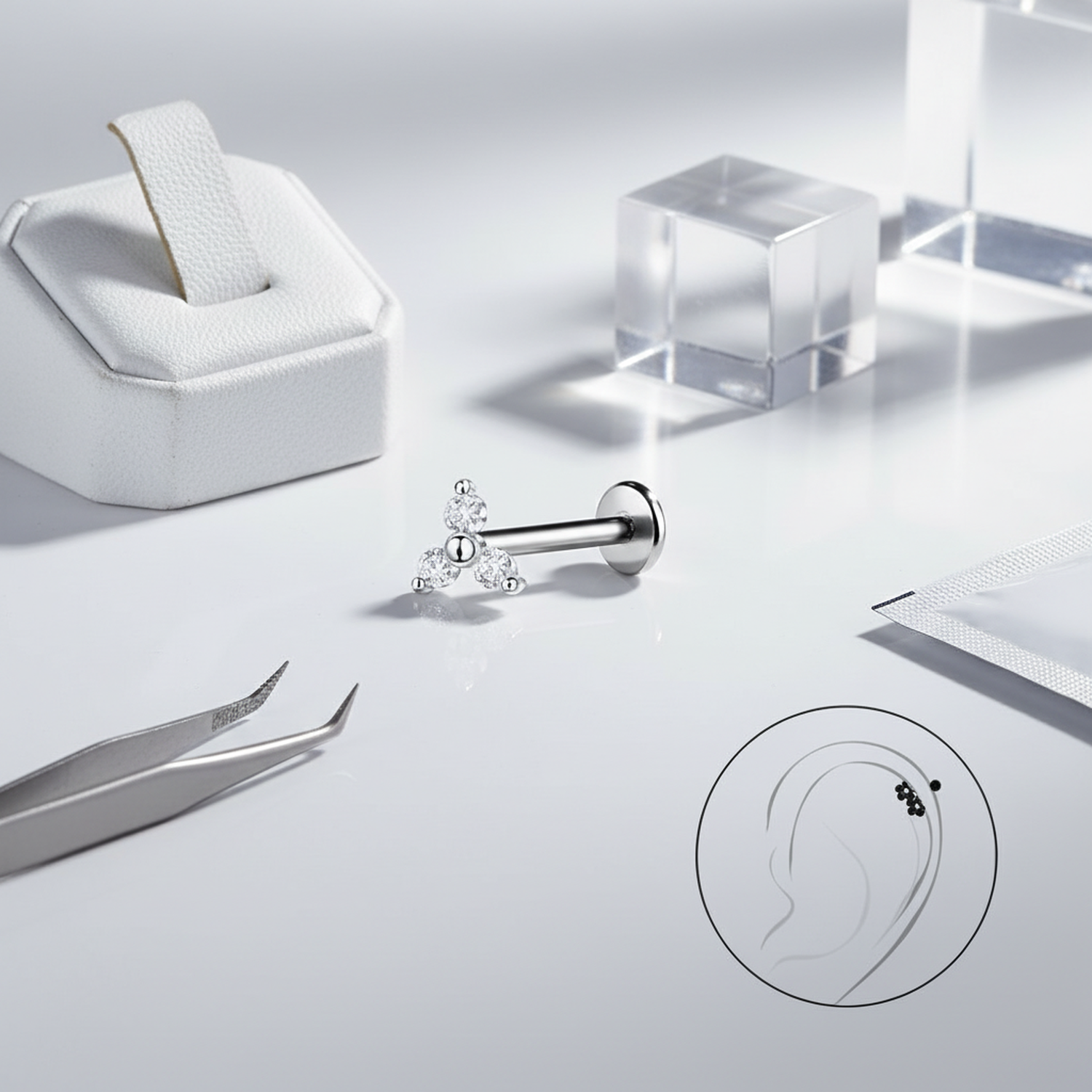 Sterling silver geometric labret stud from Melchior Jewellery displayed with tools and acrylic blocks